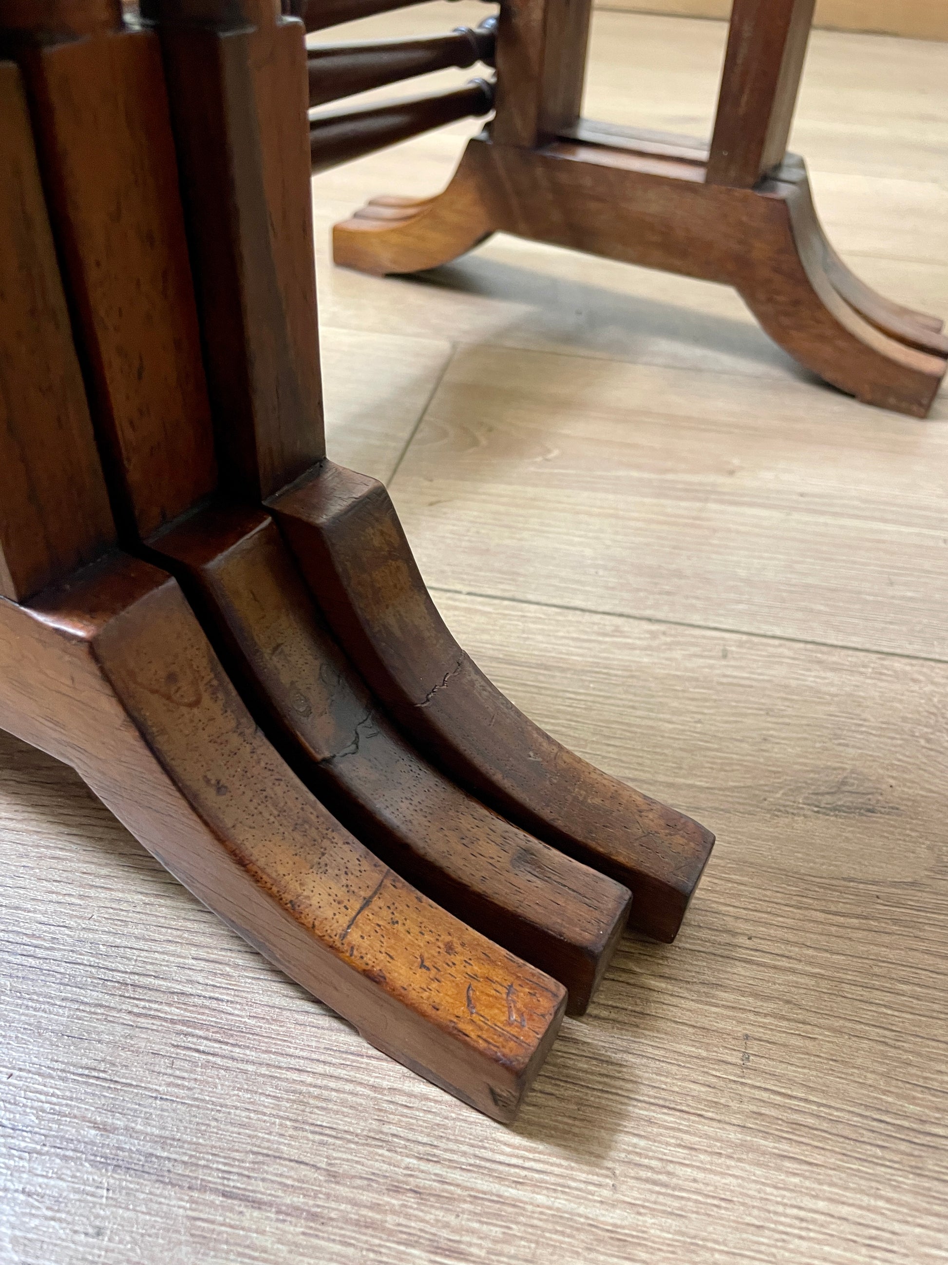 Close-up of wooden table legs on a wooden floor