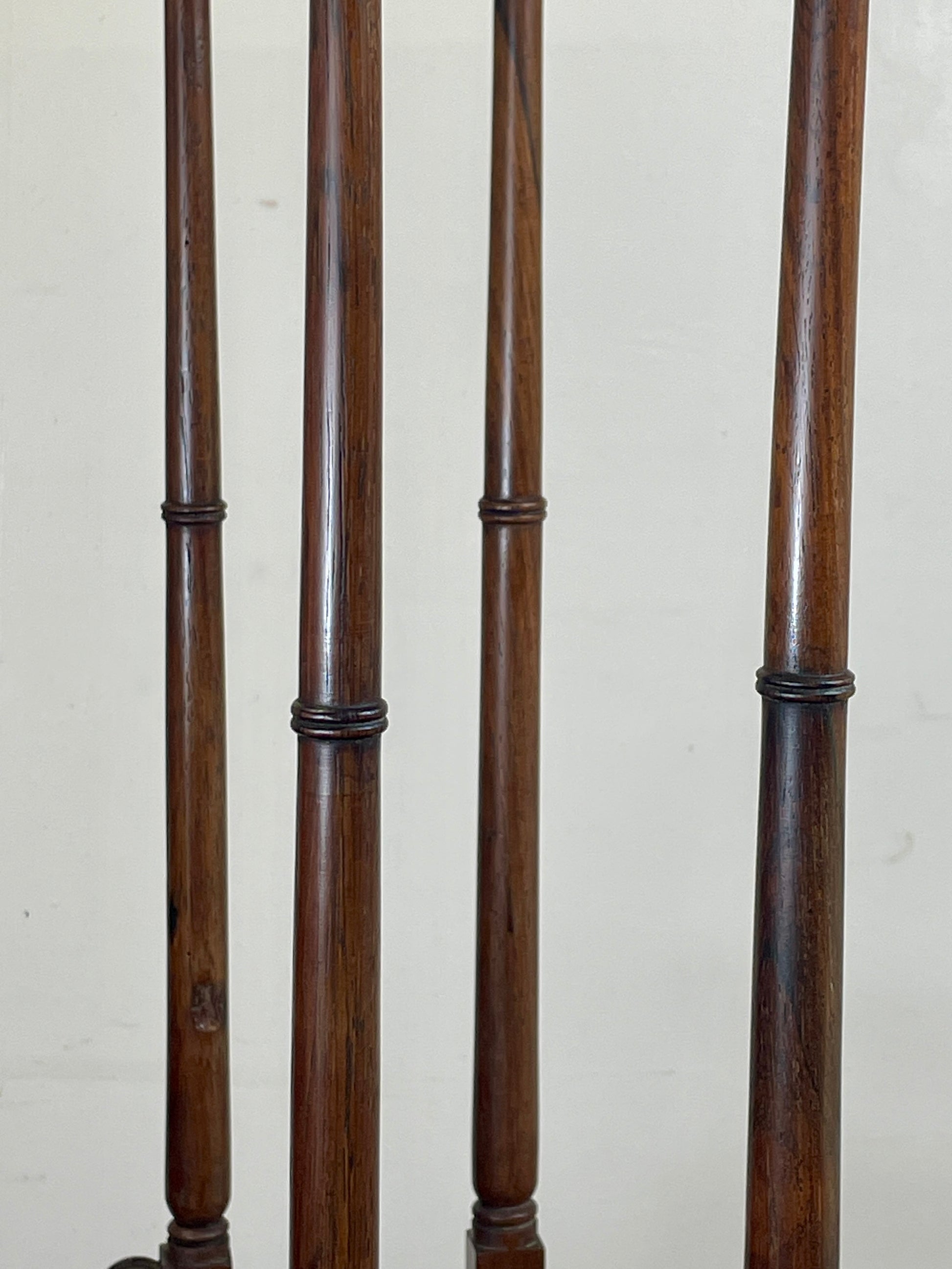 Set of dark wooden balusters against a light background