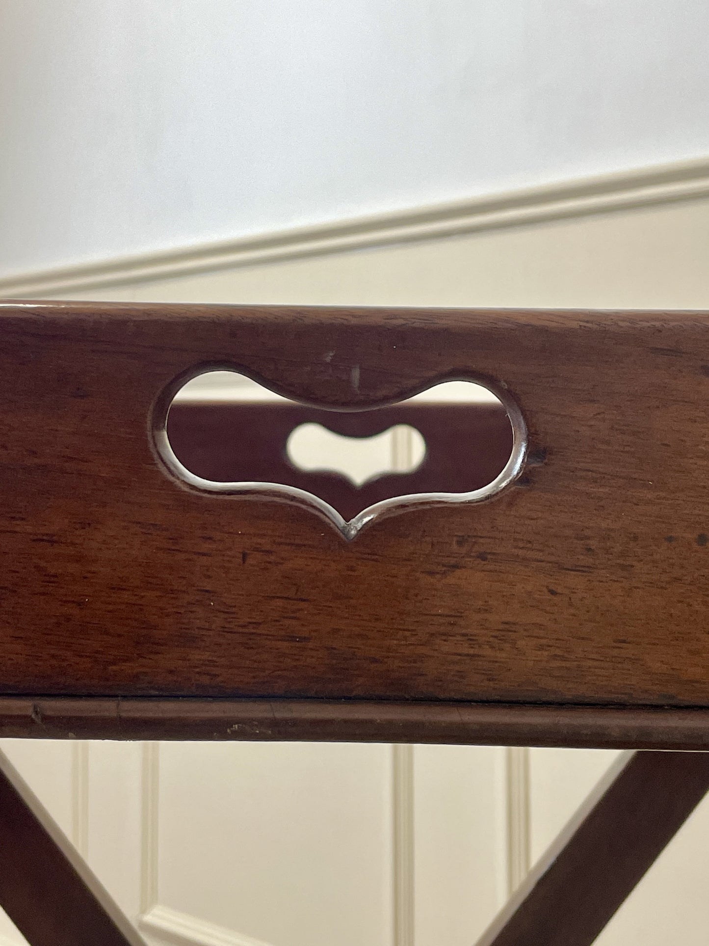 Wooden object with a heart-shaped metal pull on a white background