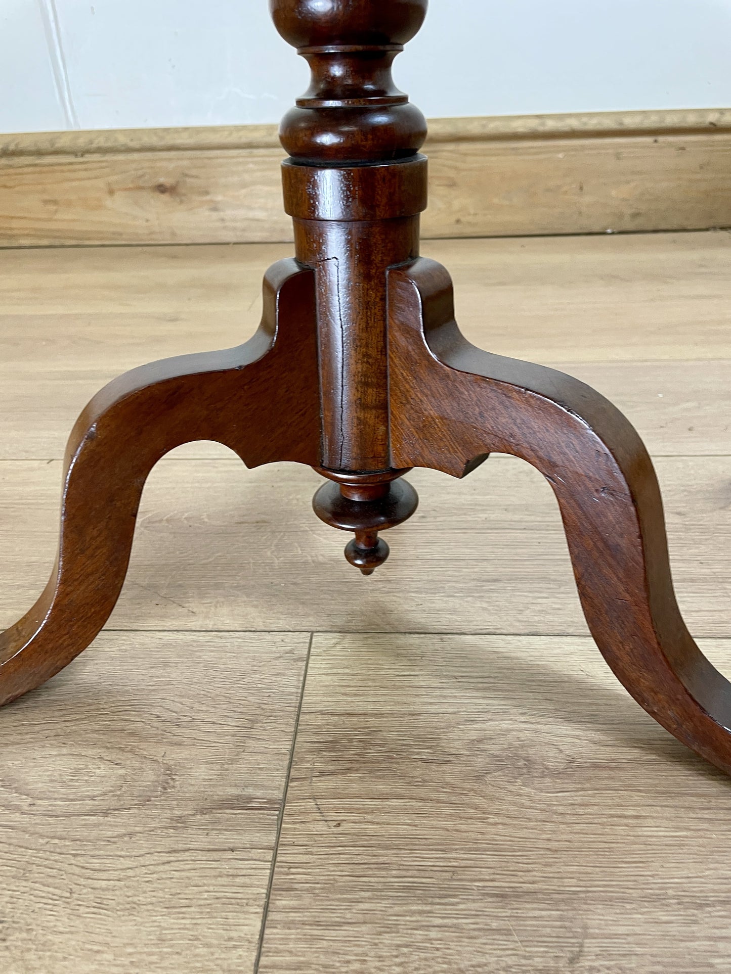 Wooden pedestal stand on a wooden floor
