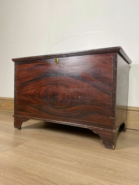 Wooden chest on a wooden floor with a white wall background