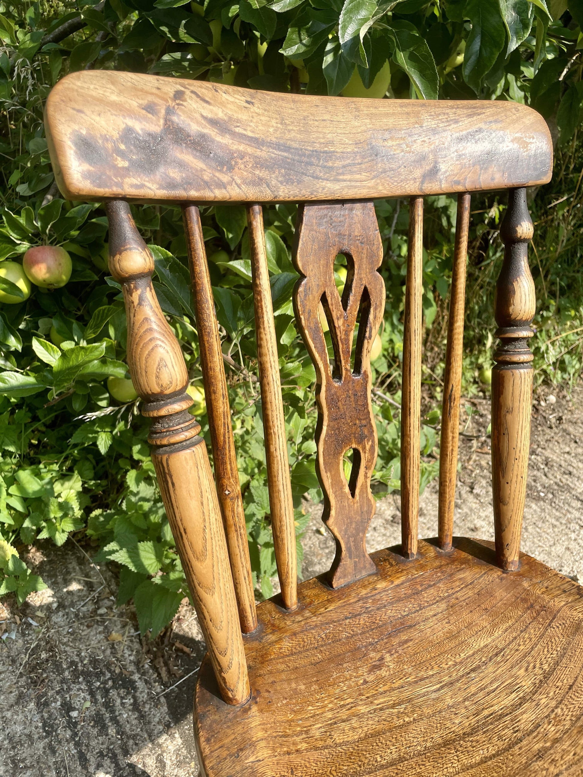 Wooden chair with intricate backrest design against a natural background