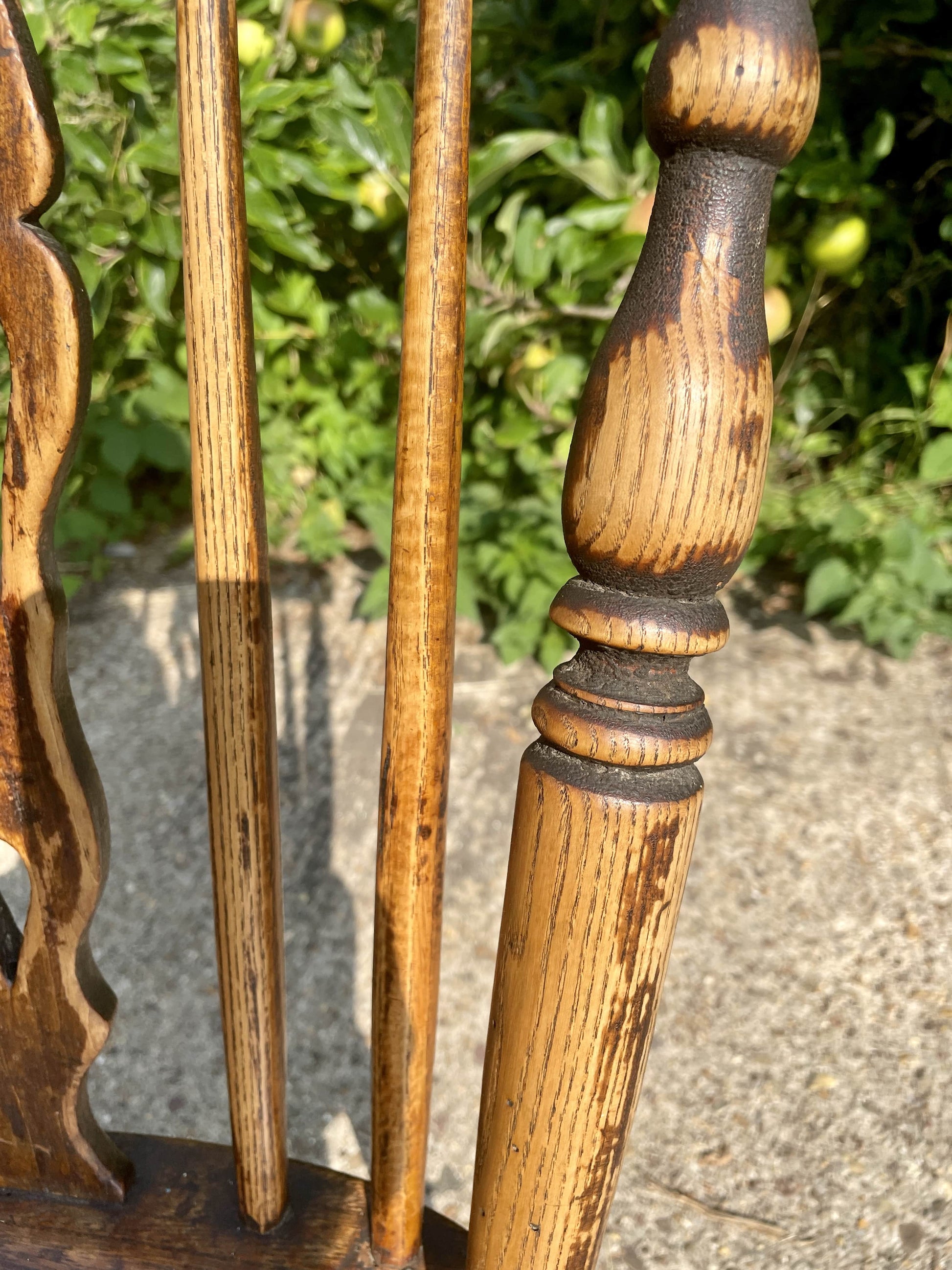 Close-up of wooden furniture back with a blurred green outdoor background
