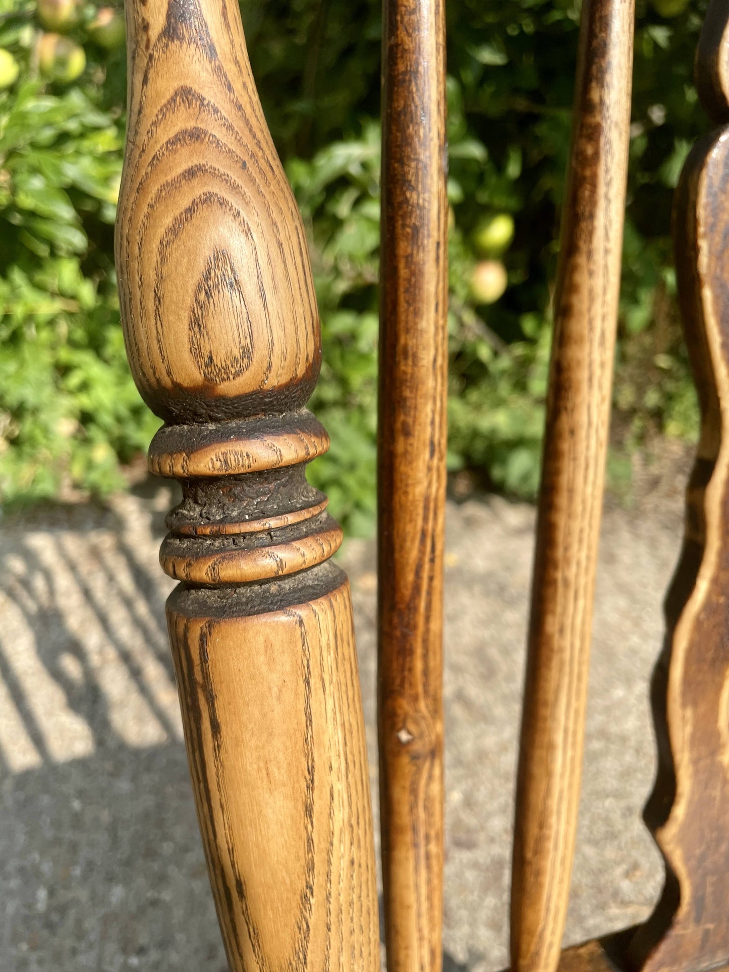 Close-up of wooden spindle with intricate grain pattern against a blurred natural background