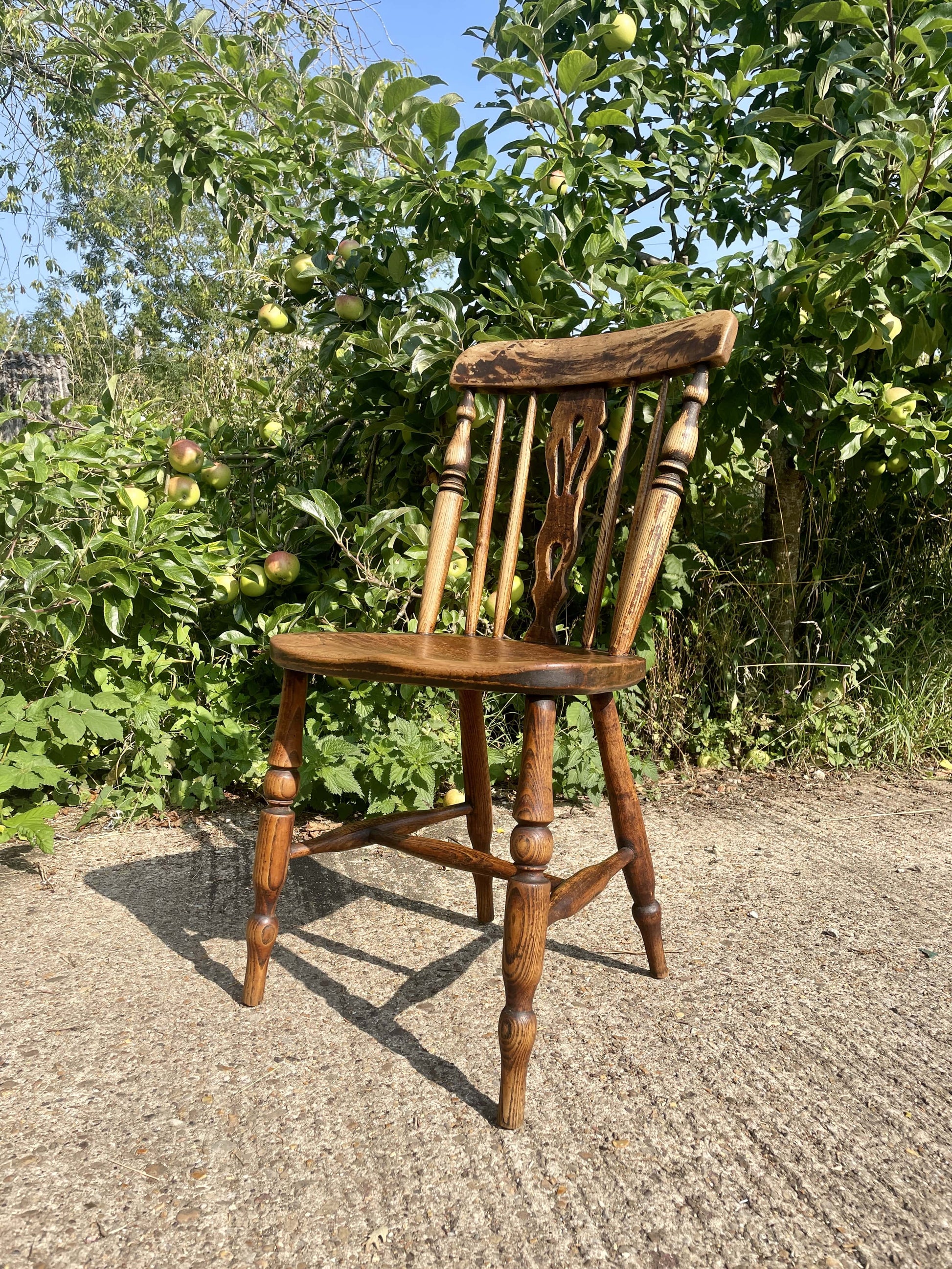 Wooden chair outdoors with greenery in the background