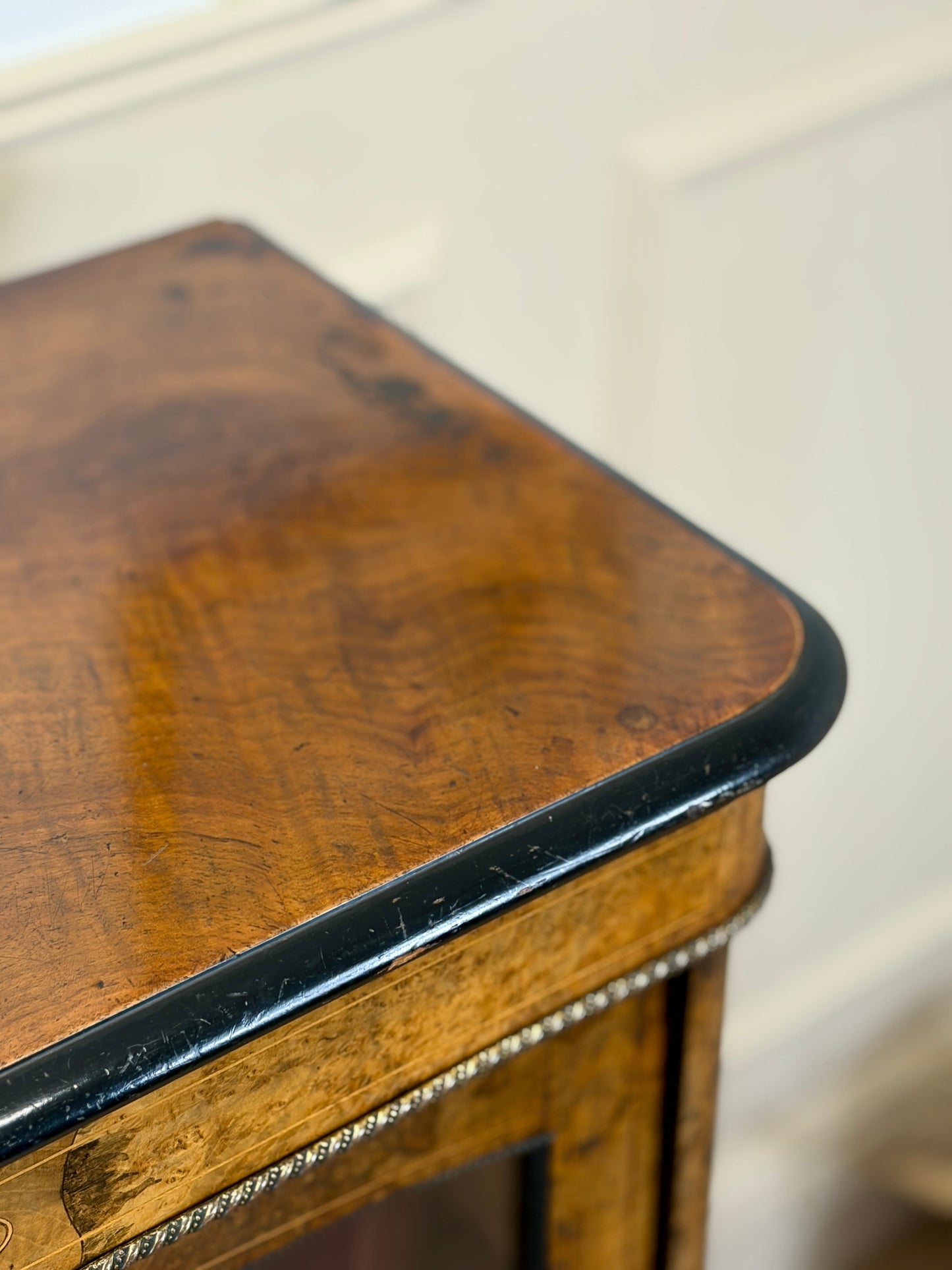 Close-up of a wooden bookcase with a black edge.