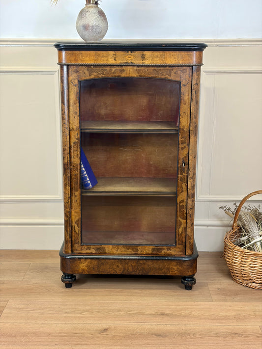 Wooden display cabinet with glass doors in a room setting