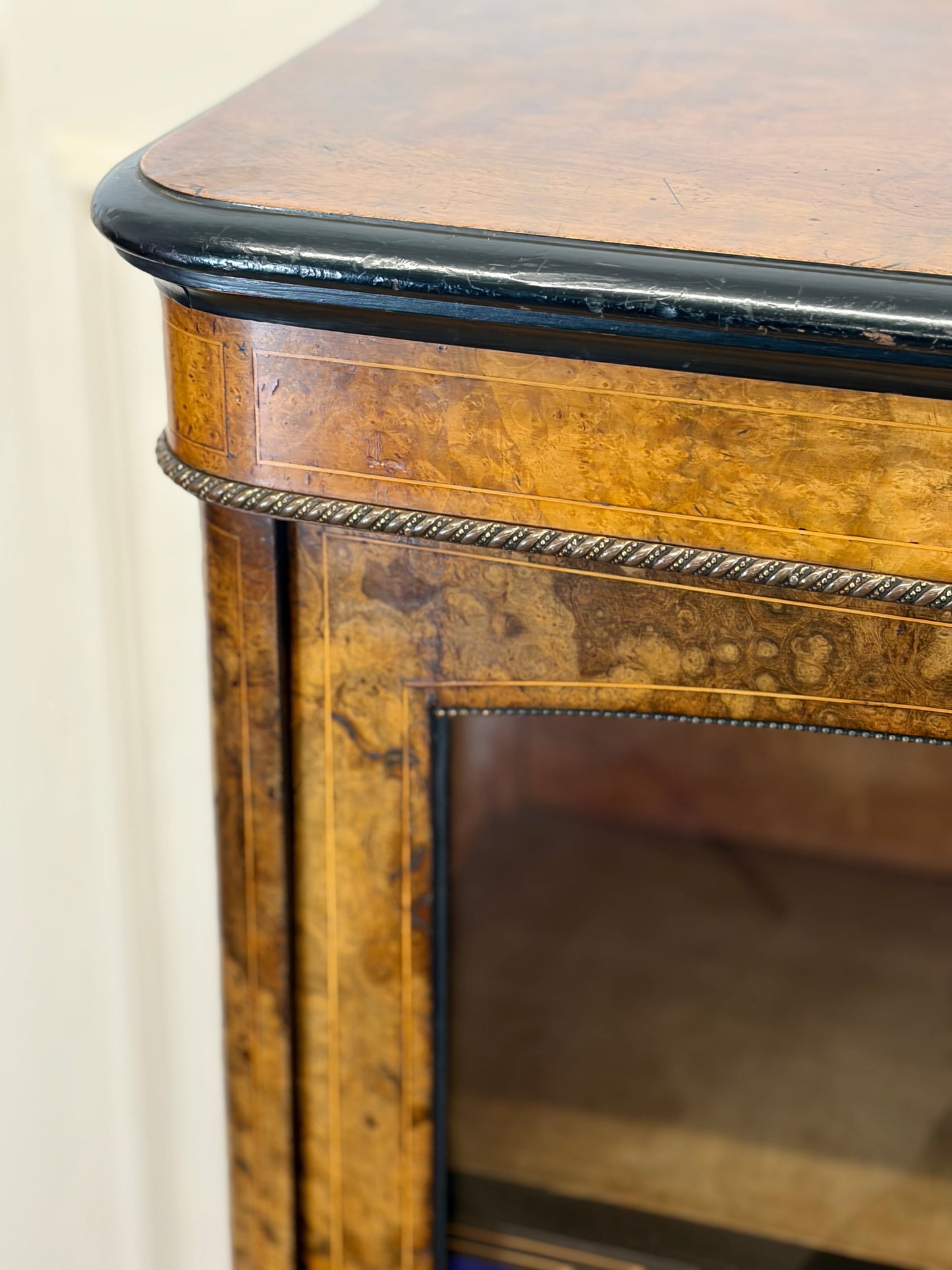 Close-up of a wooden cabinet with decorative trim and glass door.