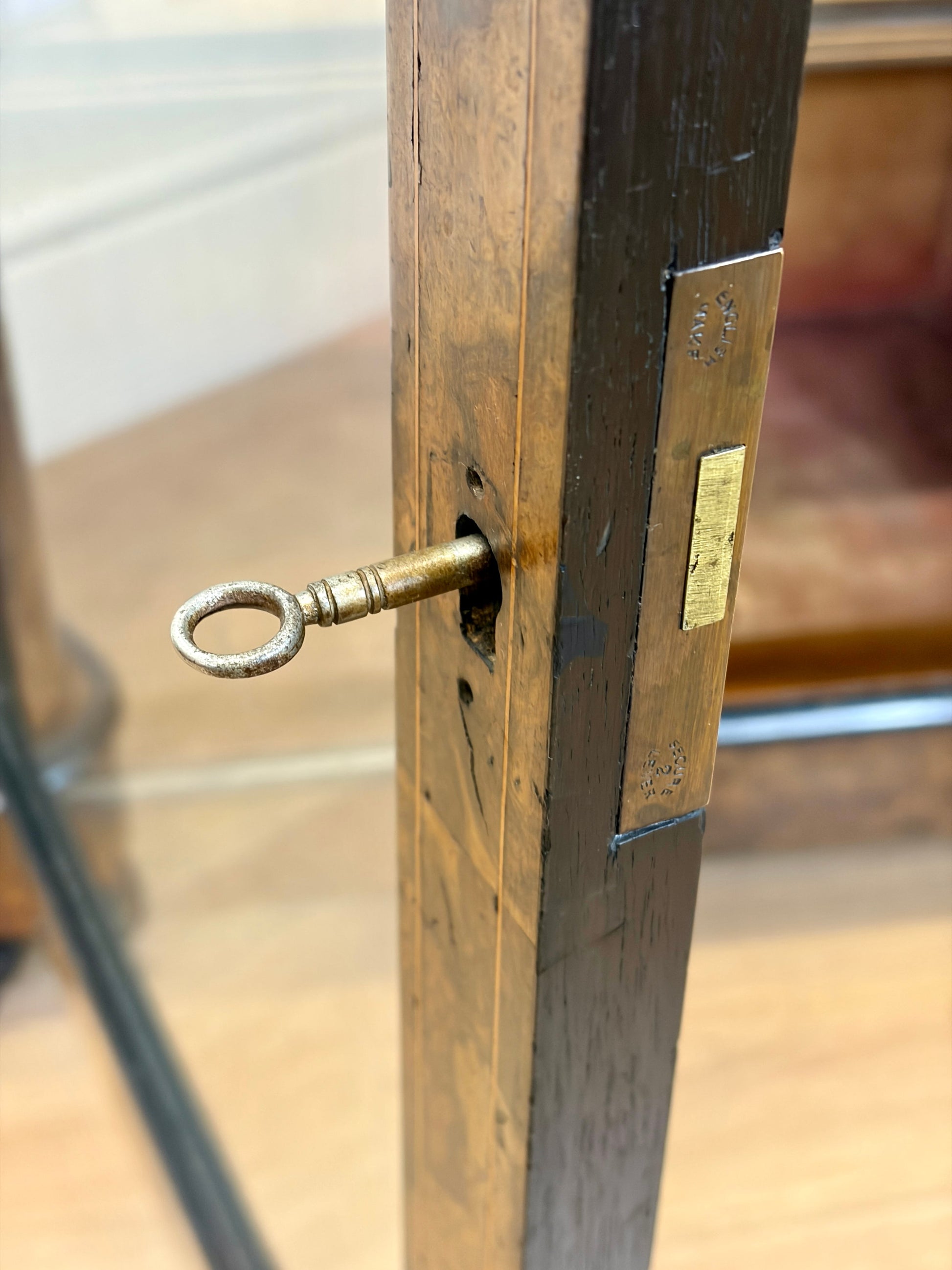 Close-up of a brass key inserted into a wooden lock mechanism.