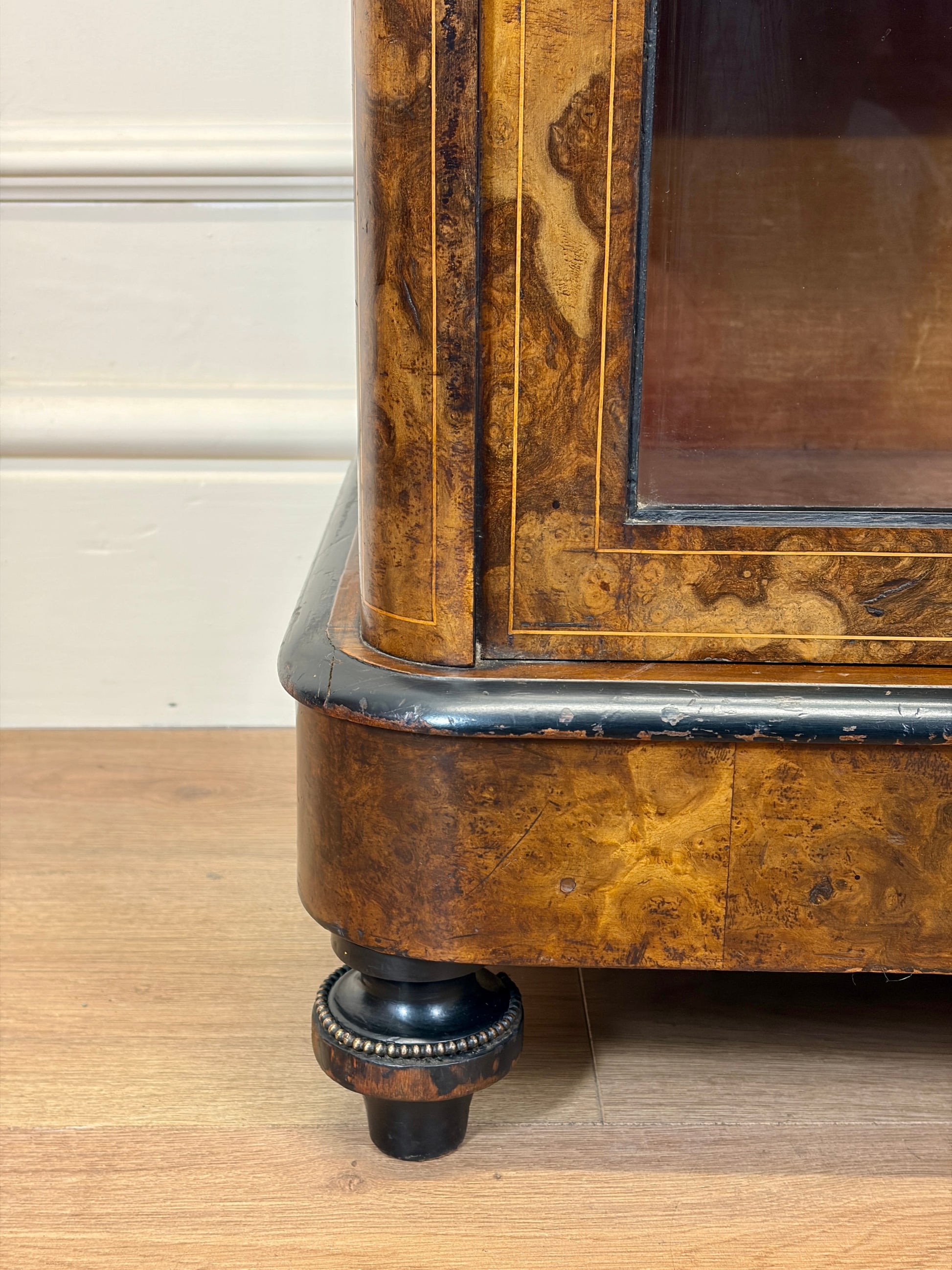 Wooden cabinet with a glass door on a wooden floor.