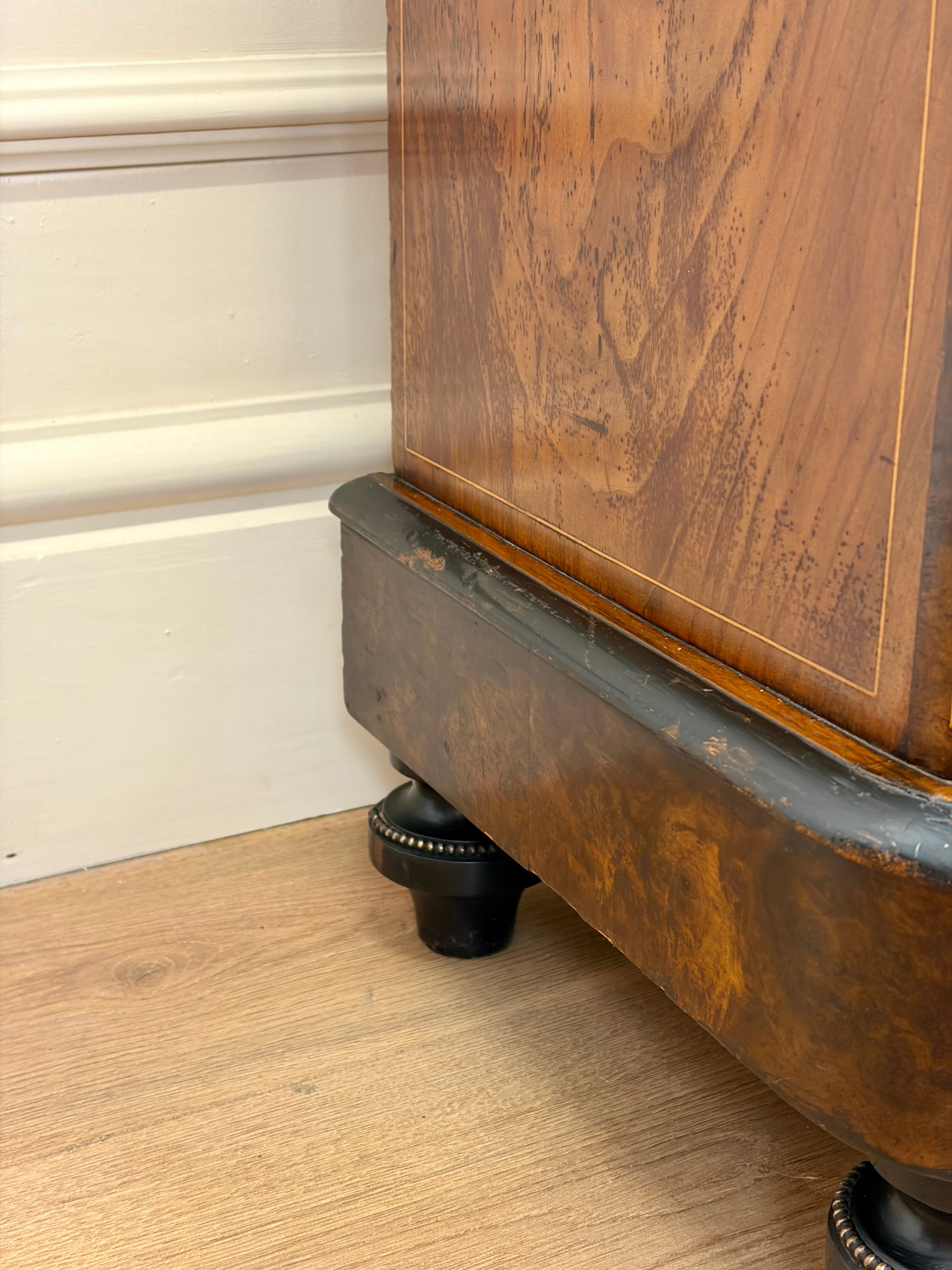 Wooden cabinet with metal base on a wooden floor