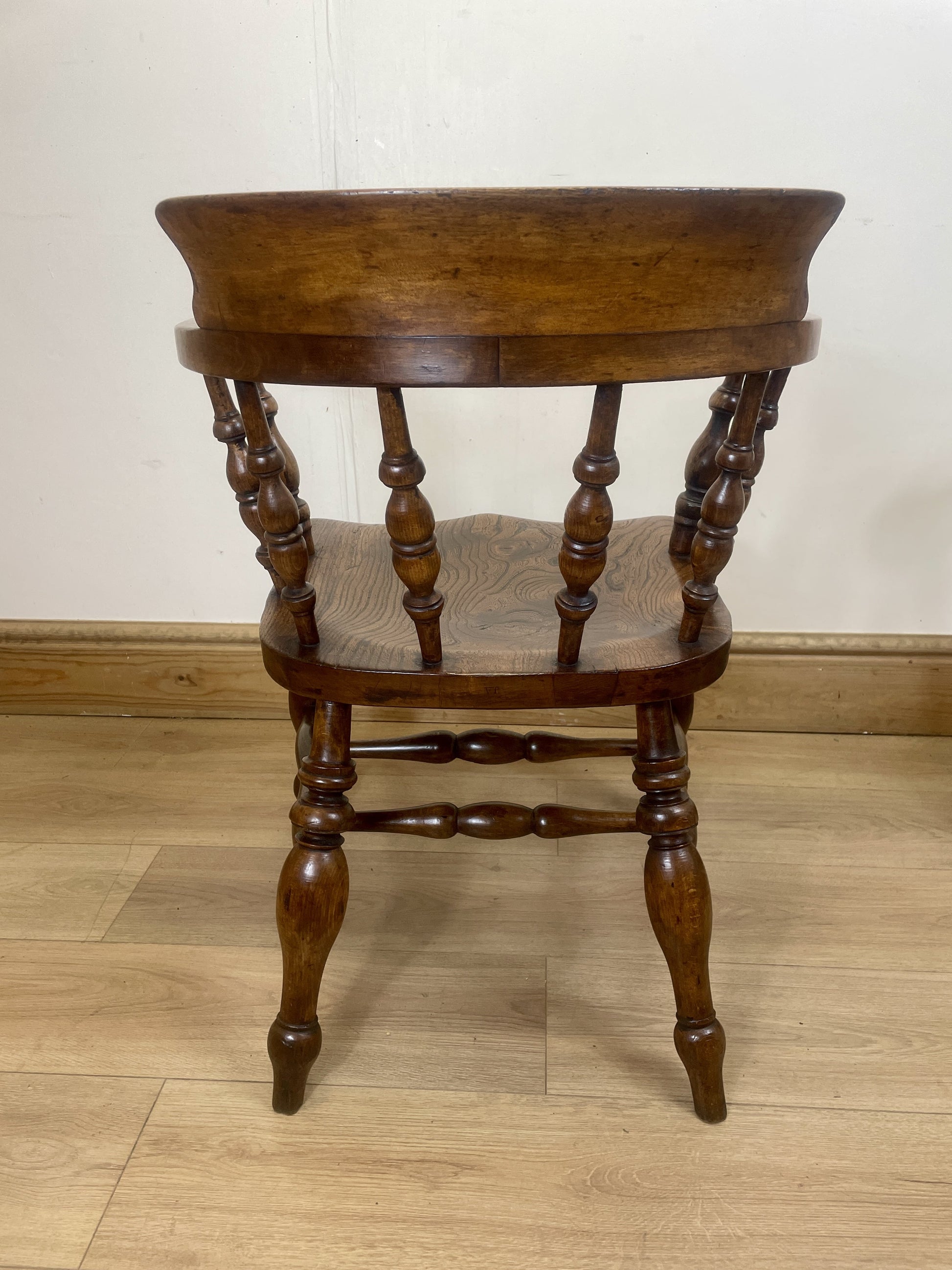 Wooden chair with turned legs on a wooden floor against a white wall