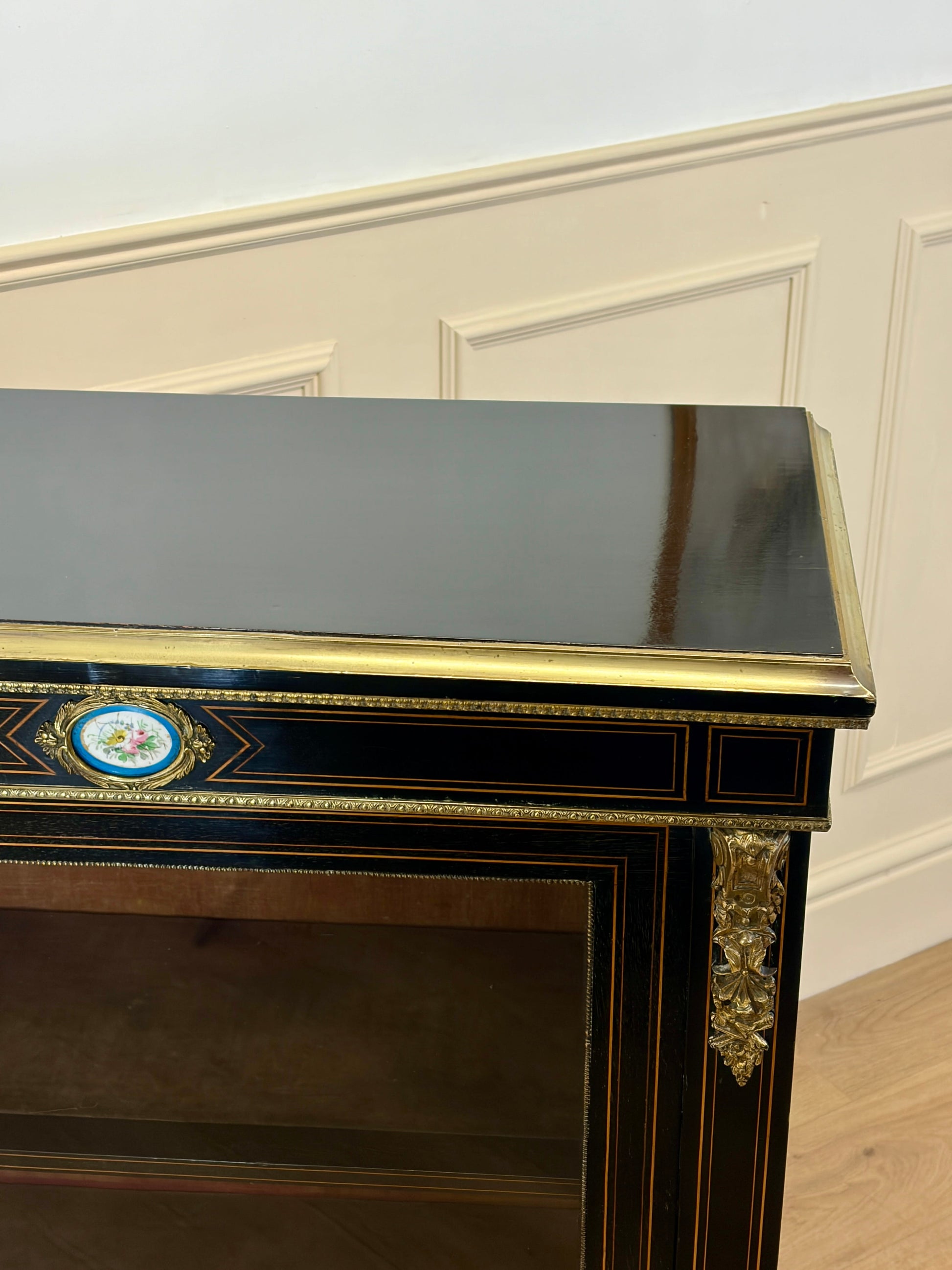 Decorative console table with gold accents against a white wall.