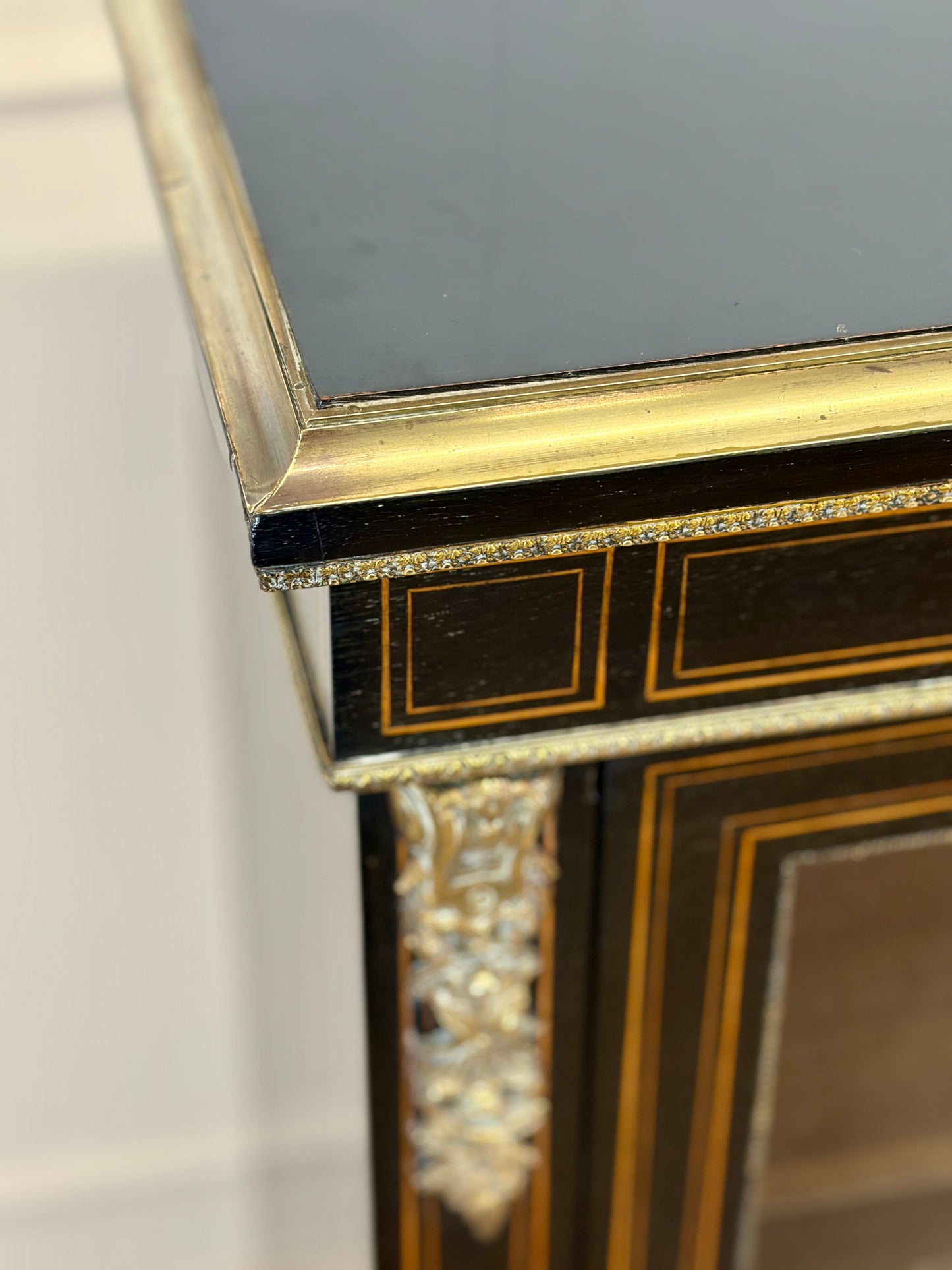 Decorative mirror with gold frame and intricate detailing on a plain background