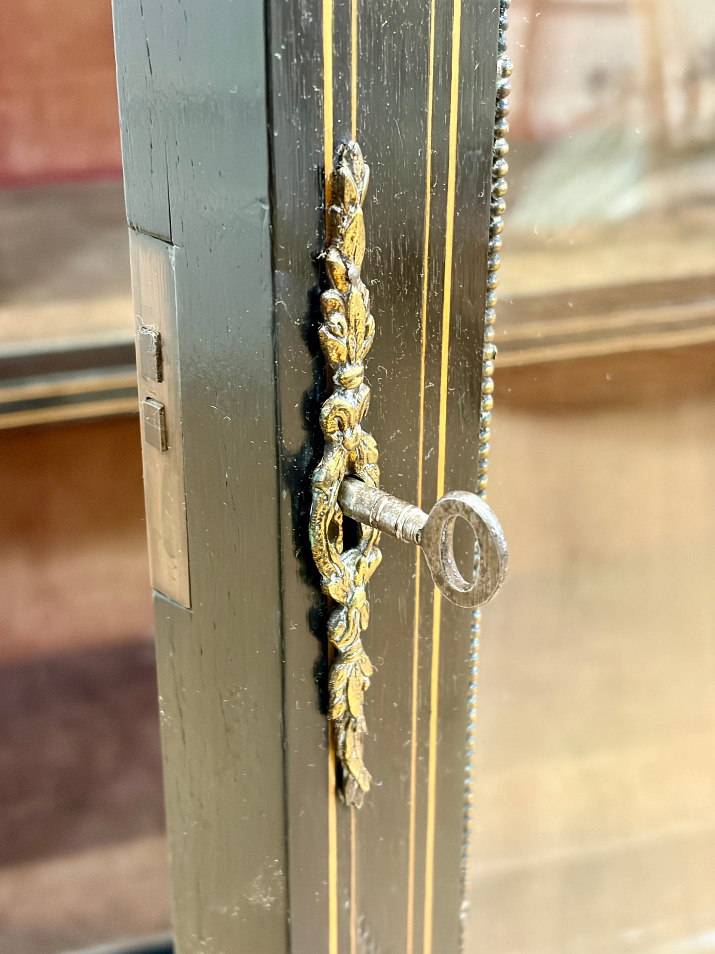 Decorative metal door handle on a wooden door with a blurred background