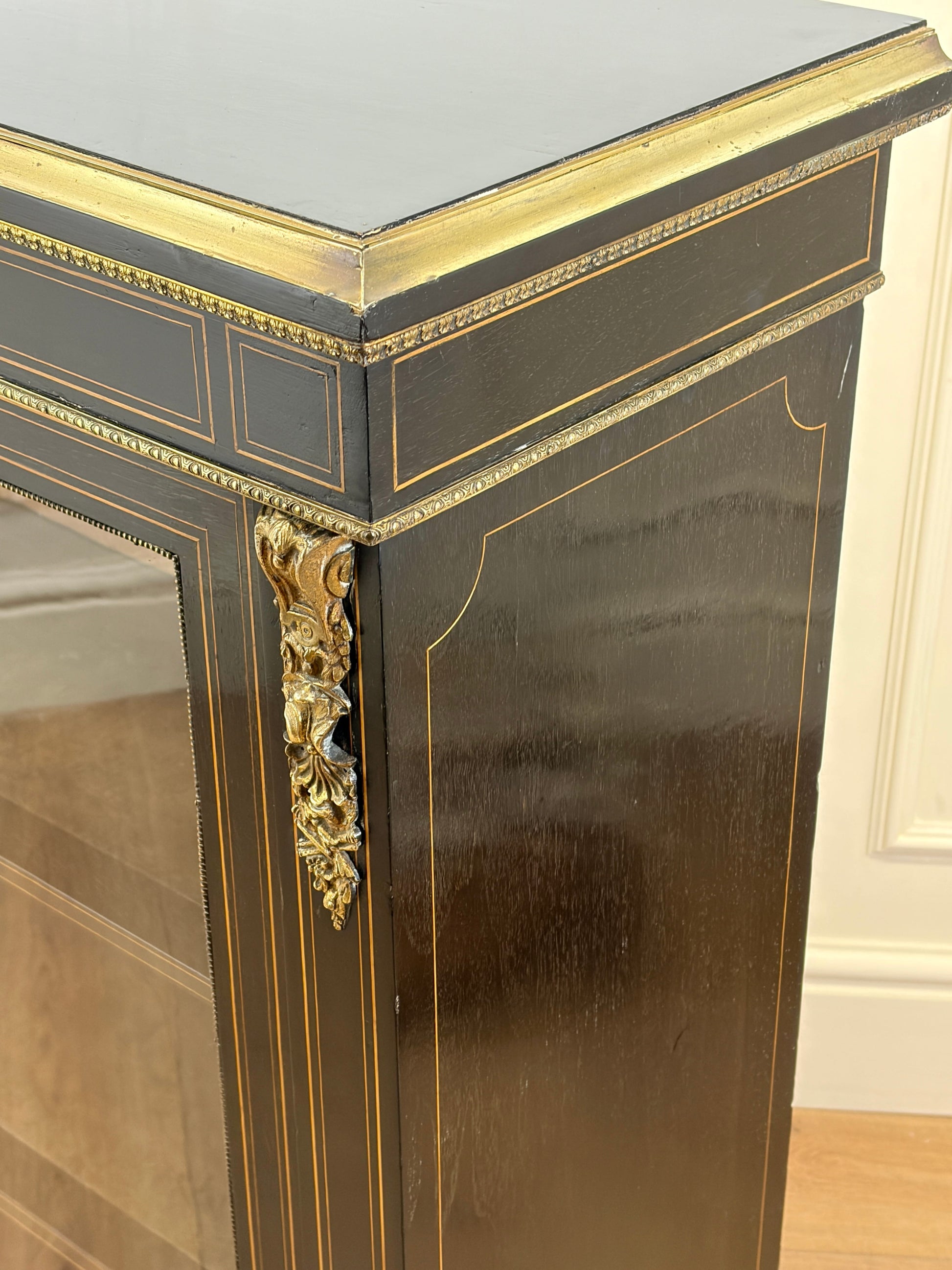 Decorative console table with gold accents and a reflective surface.