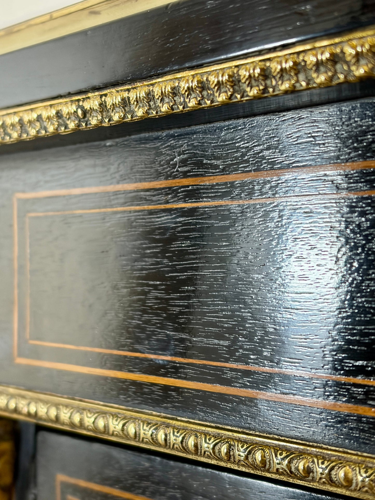 Close-up of a dark wooden surface with gold decorative trim