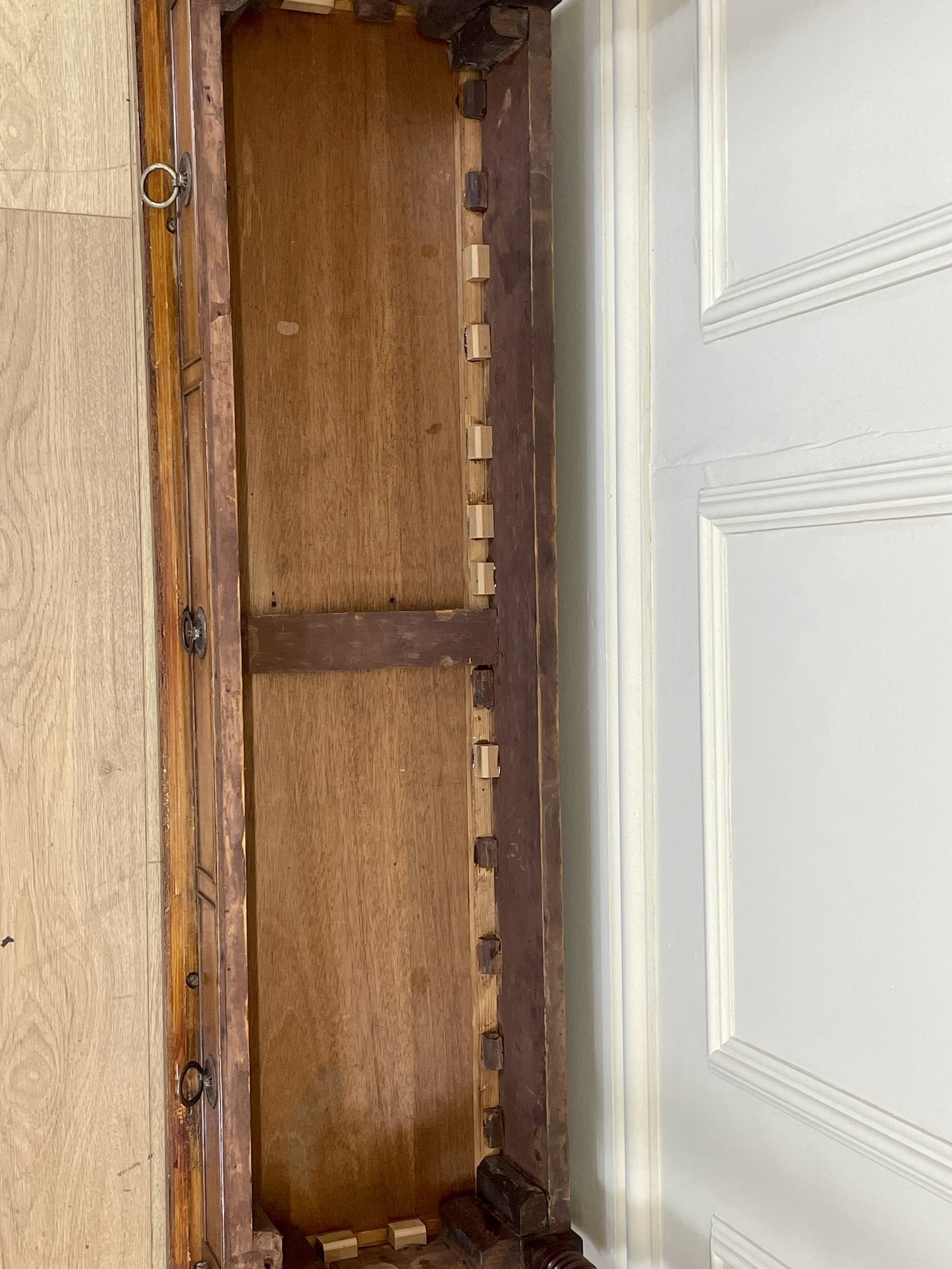 Wooden door with metal frame in a room with light-colored walls.