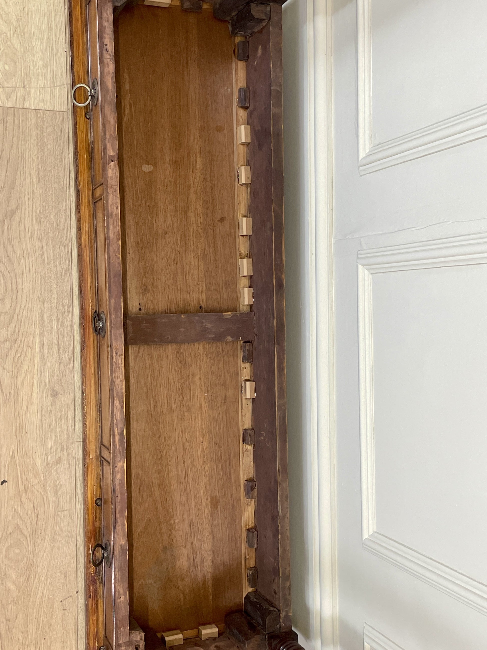 Wooden door with metal frame in a room with light-colored walls.