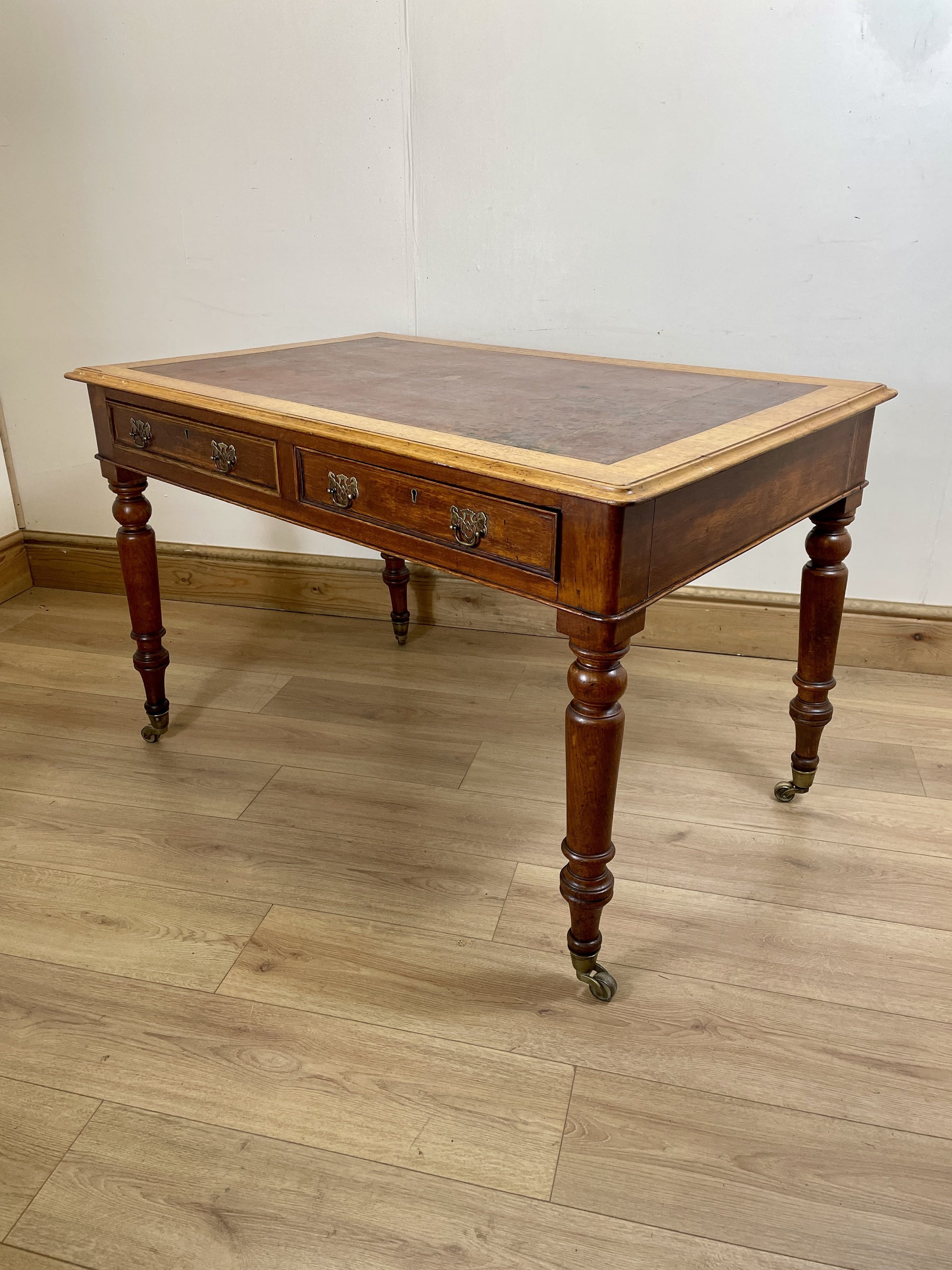 Wooden desk with leather top on a wooden floor