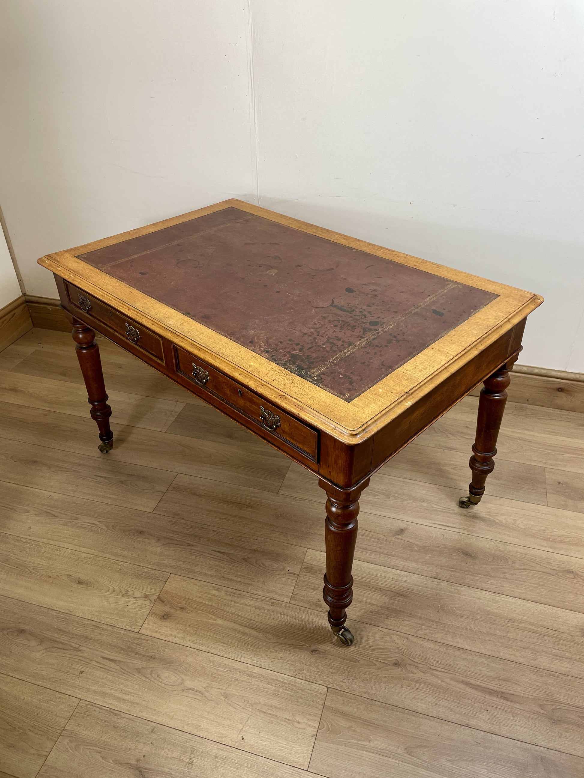 Wooden desk with leather top on a wooden floor