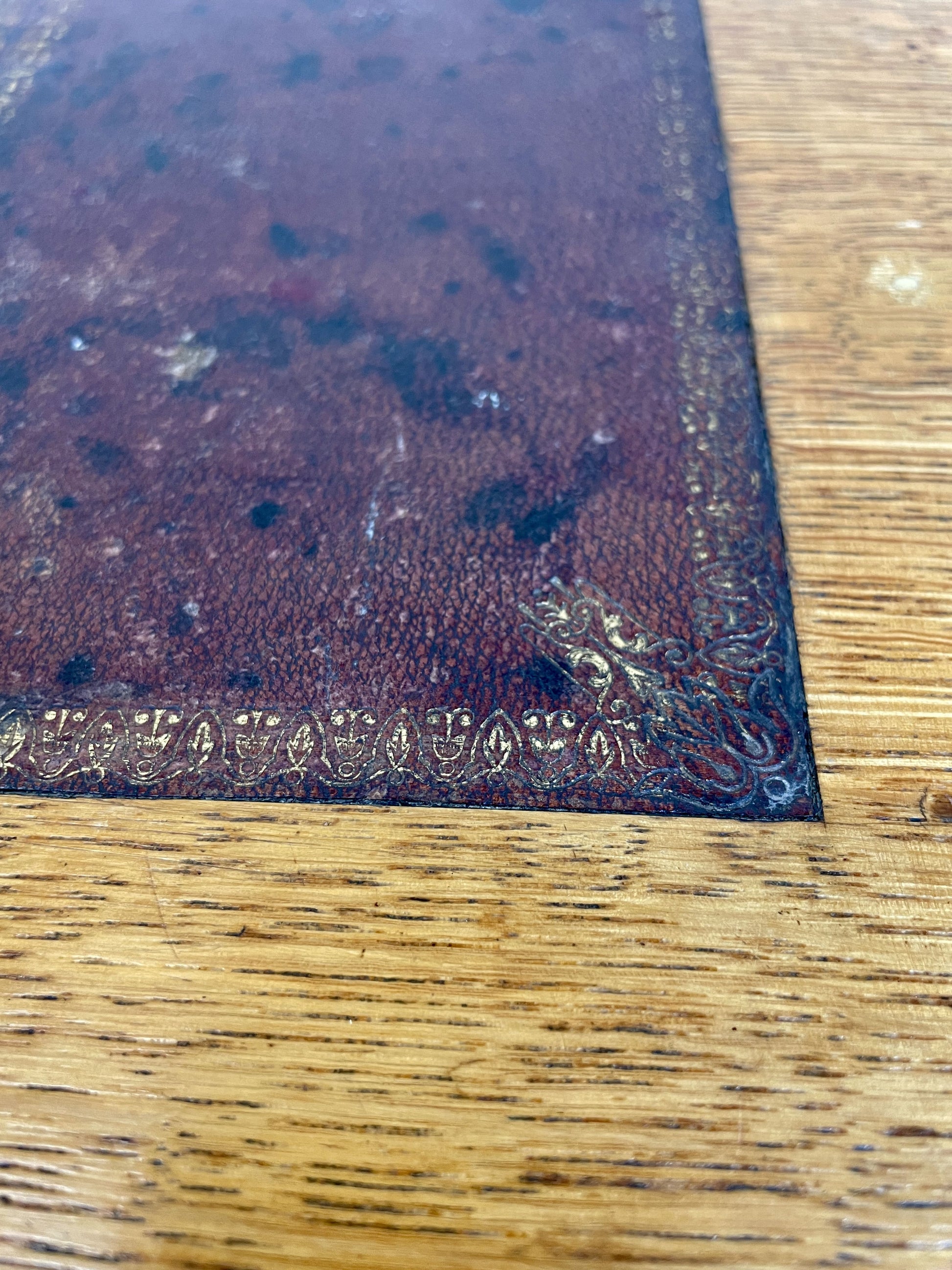 Close-up of a textured brown leather sample on a wooden surface