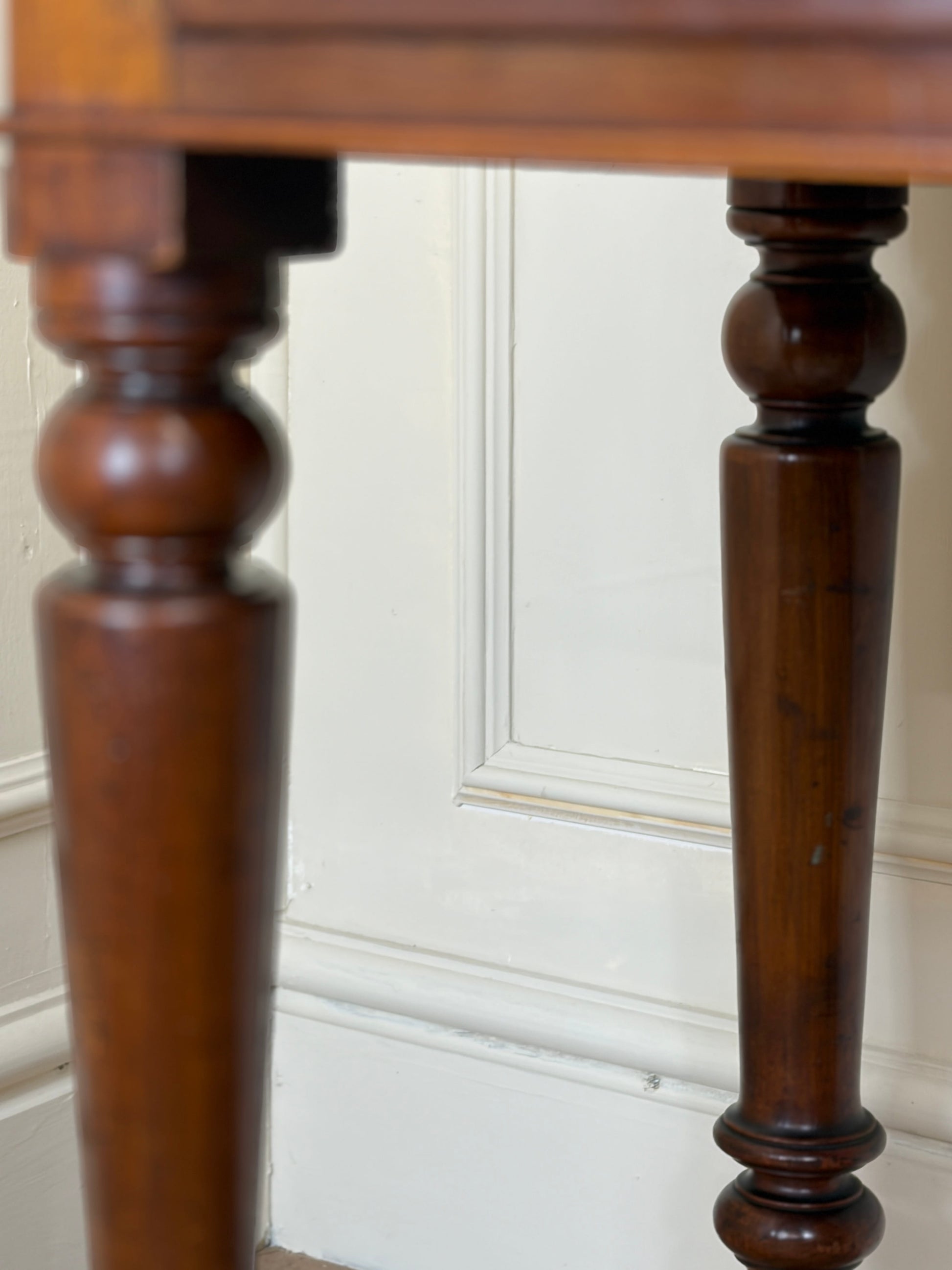 Close-up of wooden legs against a white wall