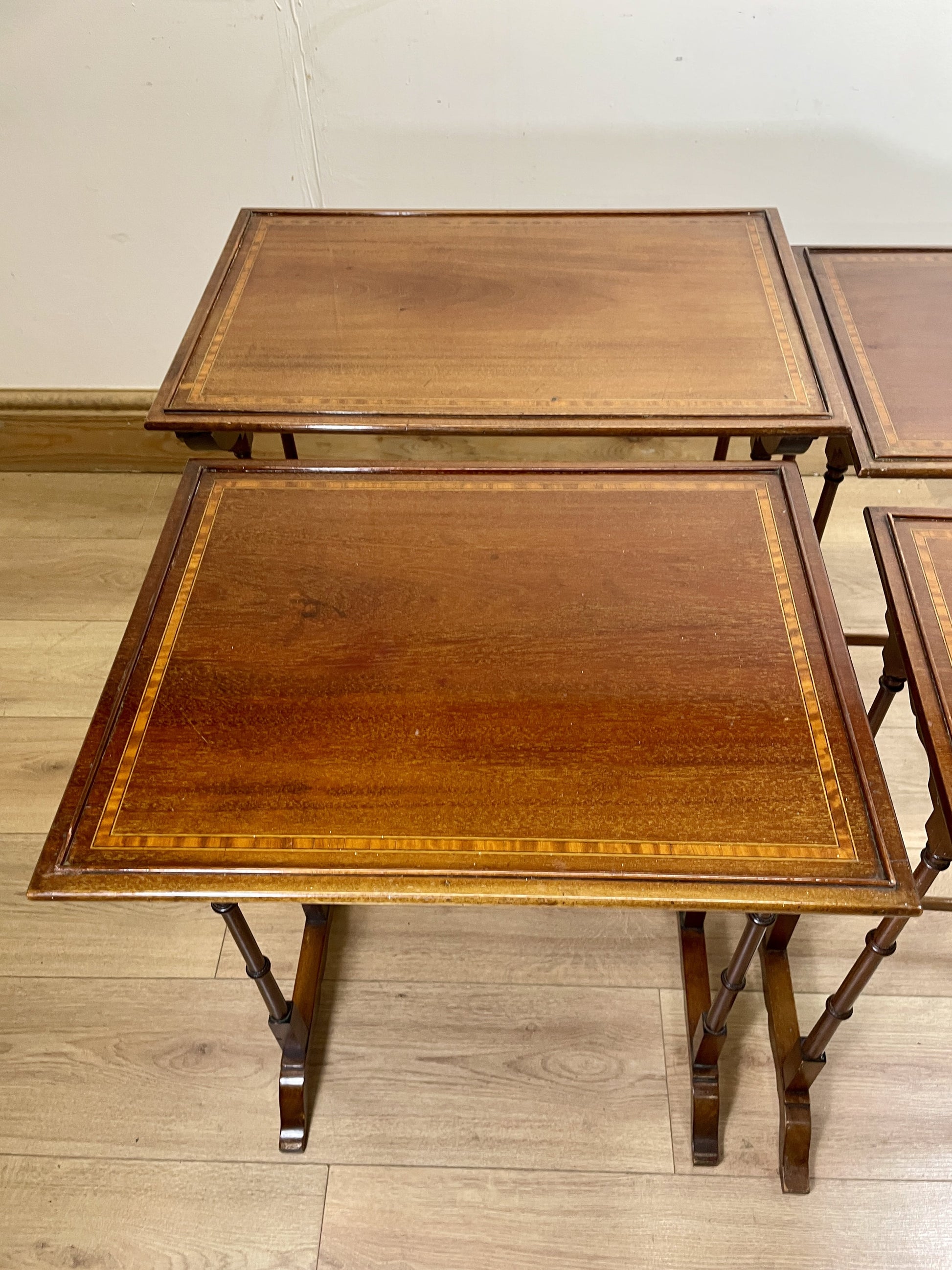 Set of wooden nesting tables on a wooden floor.