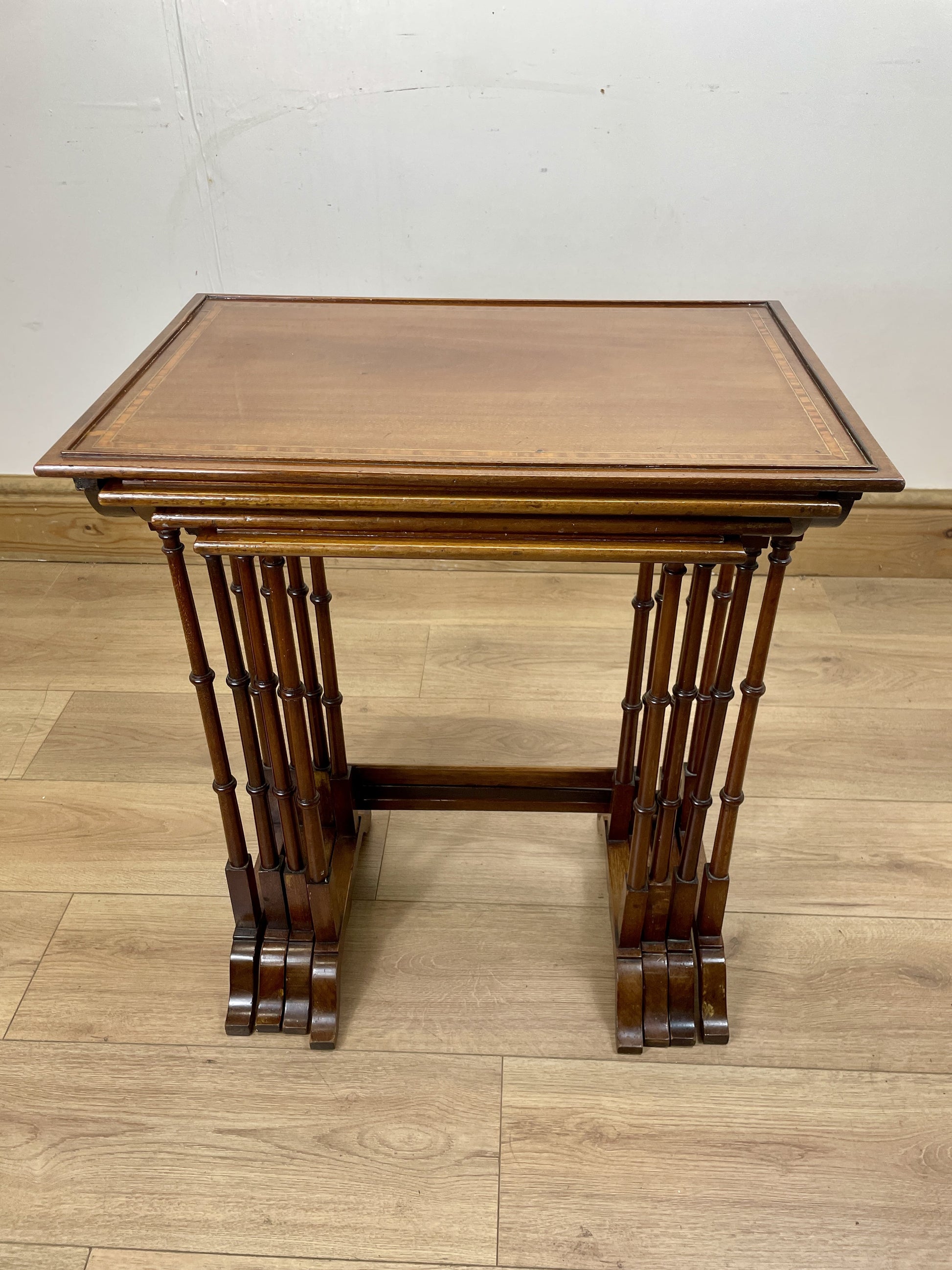 Wooden side table on a wooden floor with a white wall background