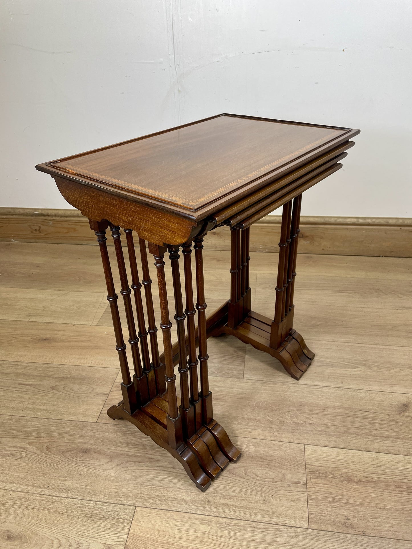 Wooden side table with a slanted top on a wooden floor.
