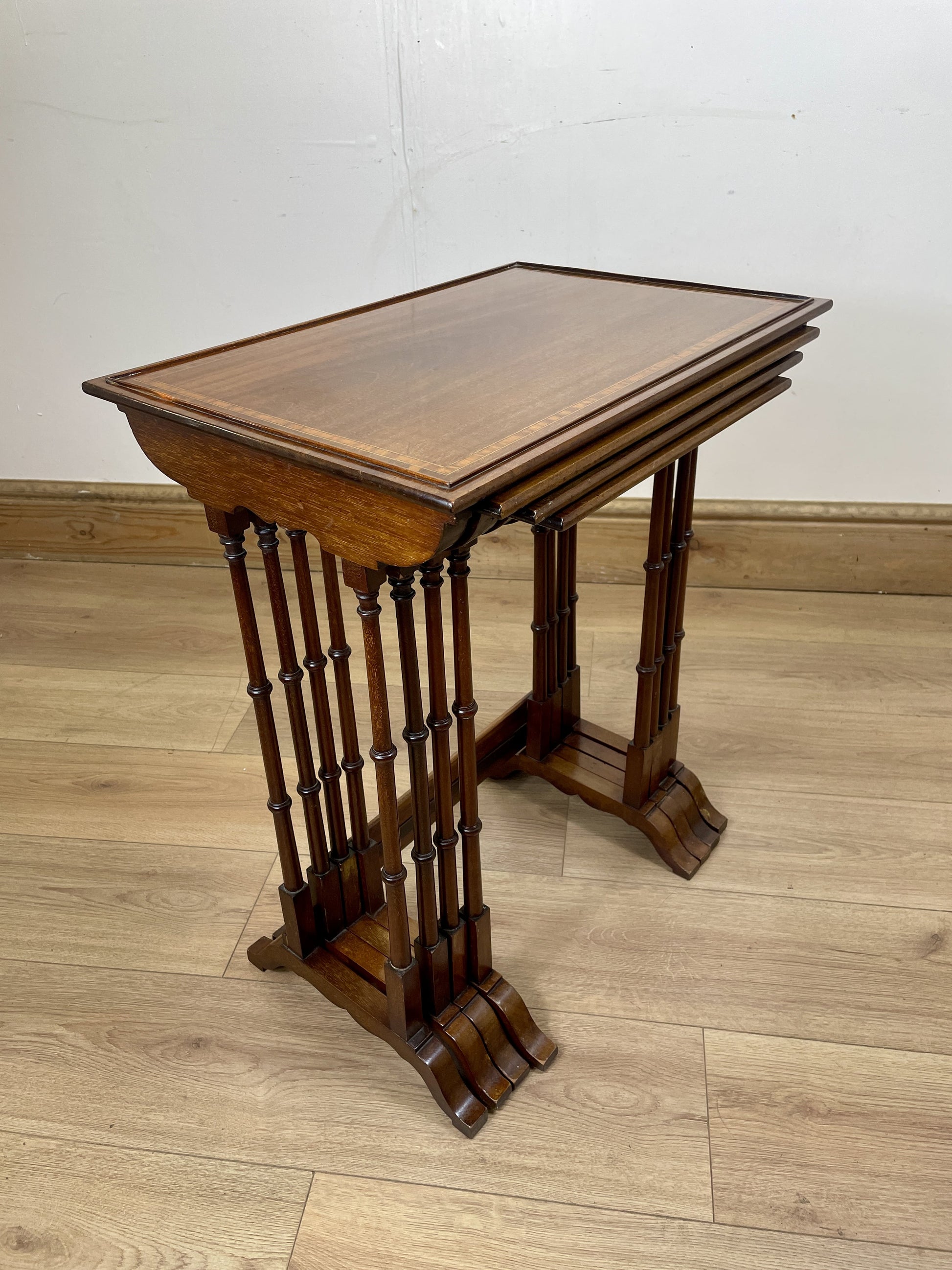Wooden side table with a slanted top on a wooden floor.