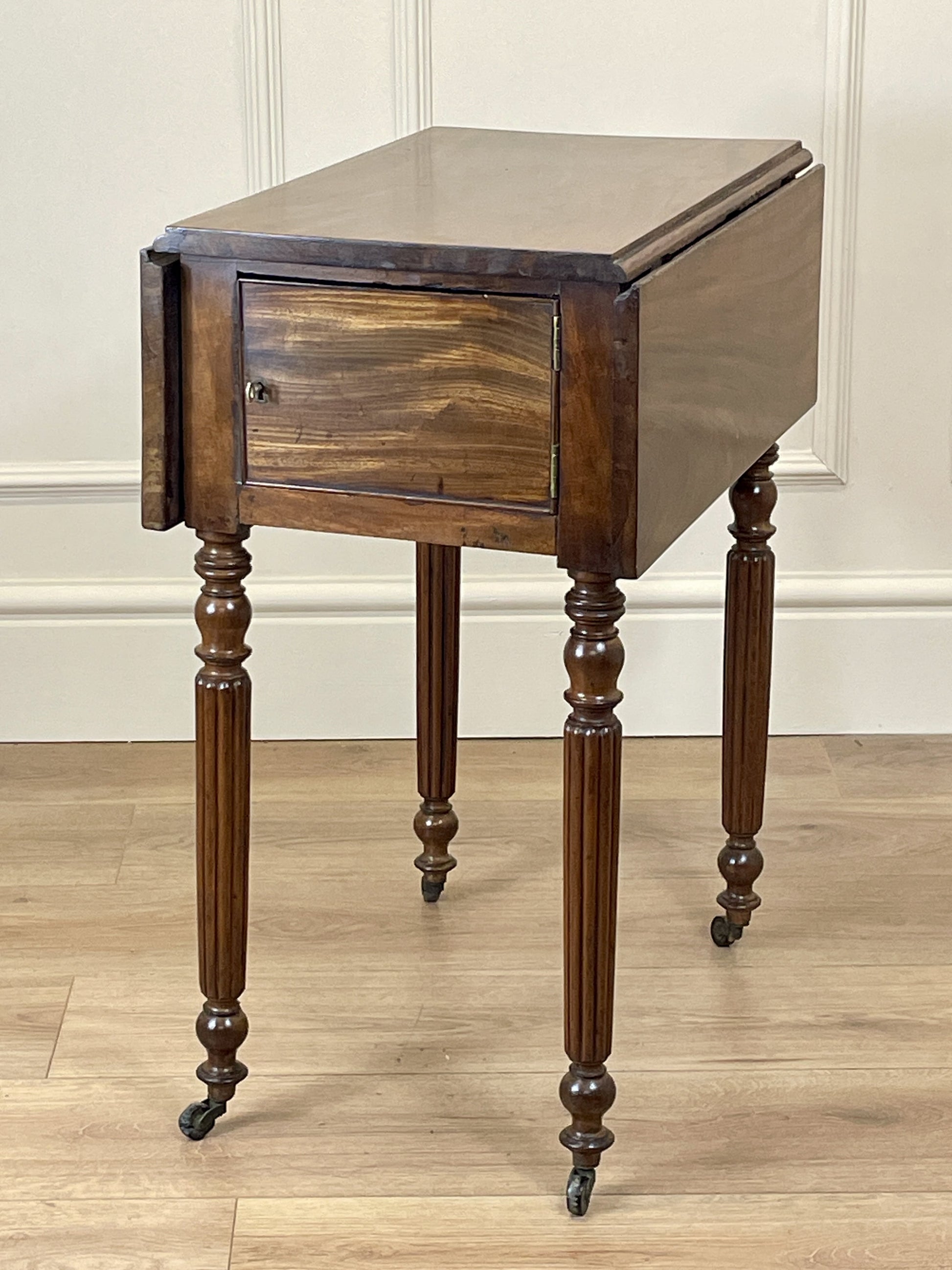 Wooden side table with a drawer on a wooden floor