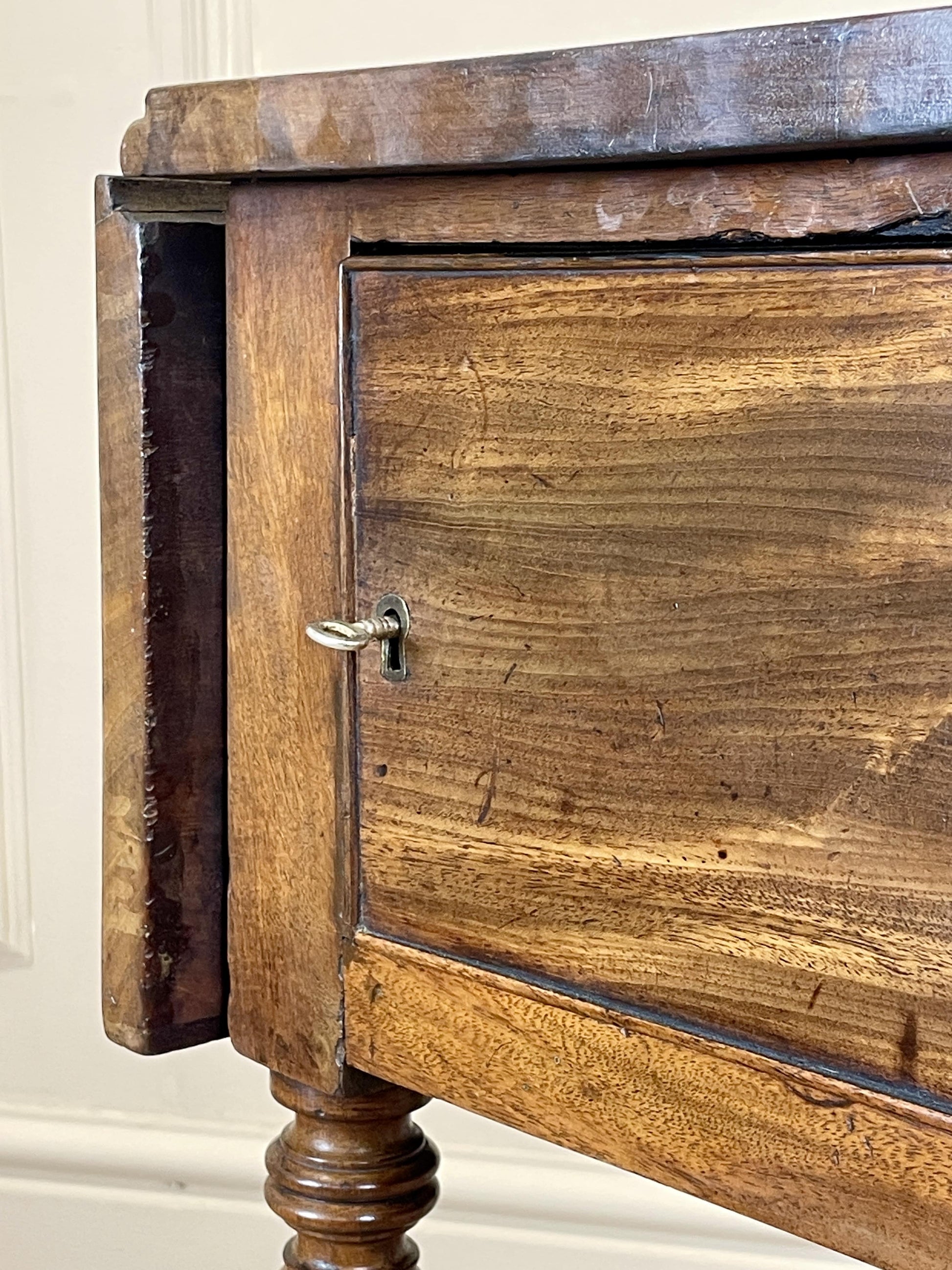 Close-up of a wooden cabinet with a door open, showing a metal handle.