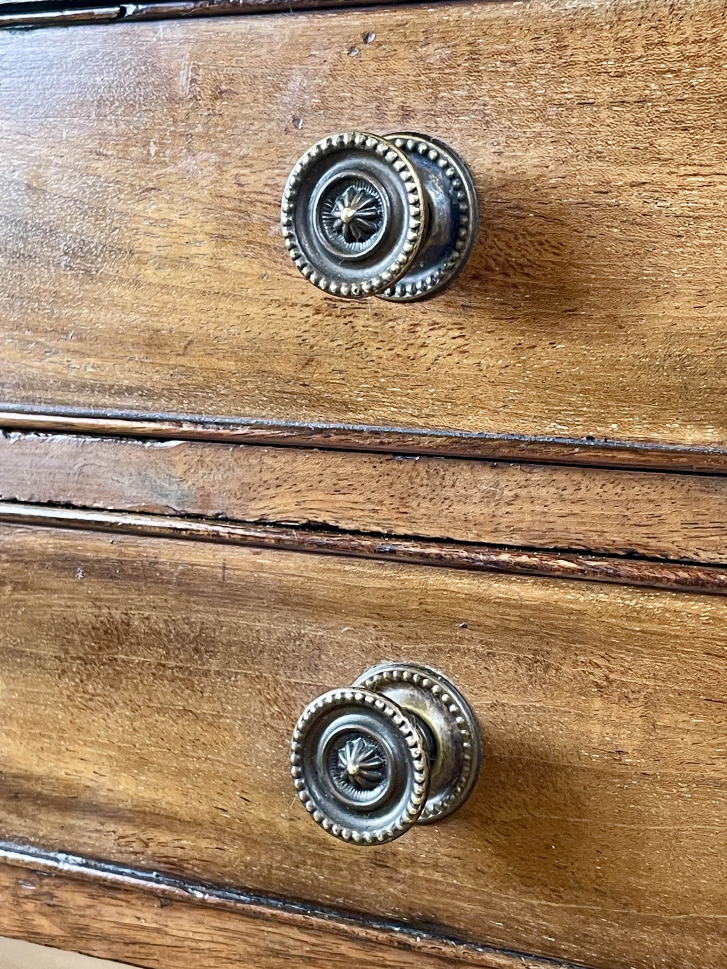 Wooden drawer with metal knobs on a wooden surface