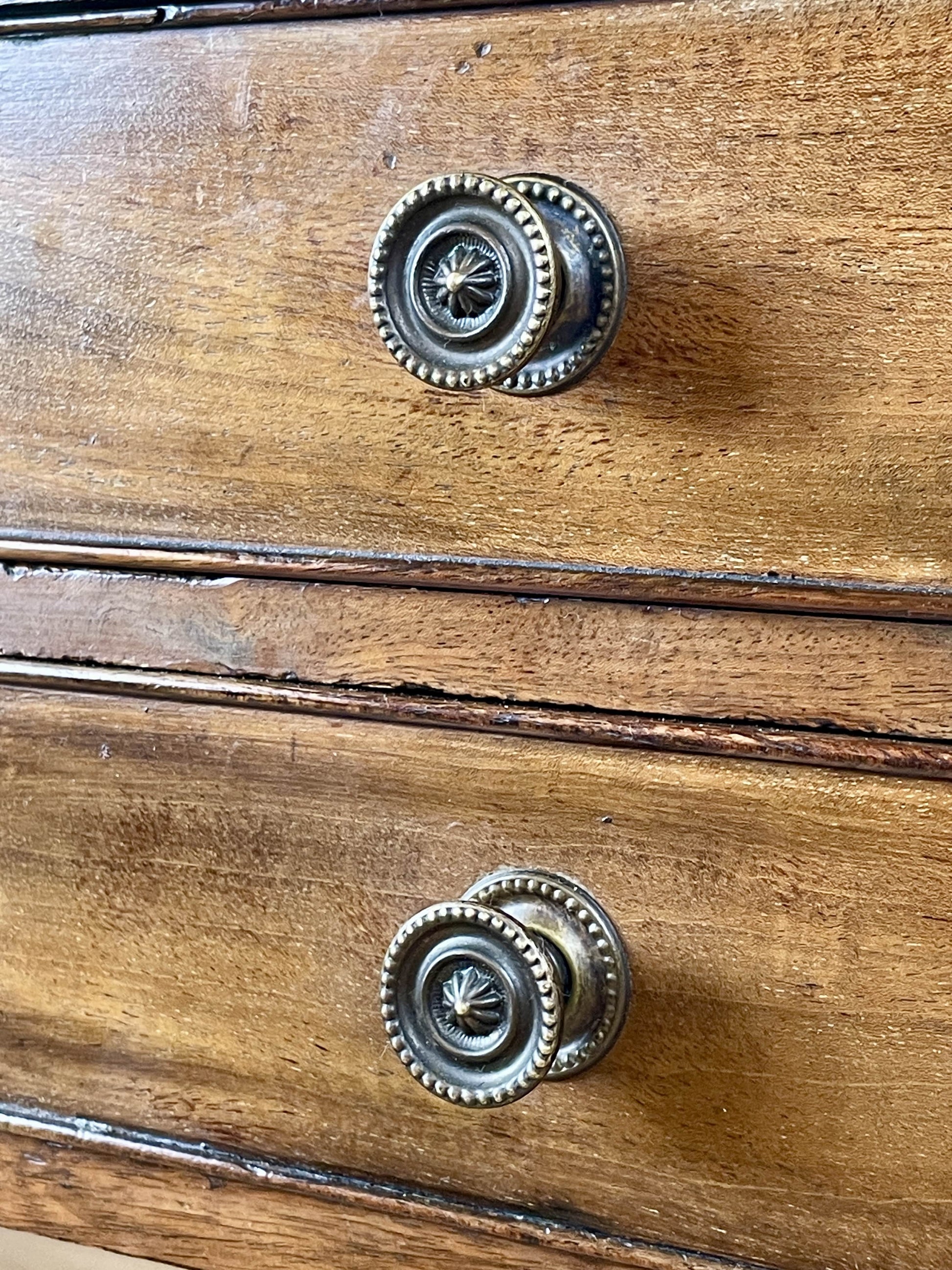 Wooden drawer with metal knobs on a wooden surface