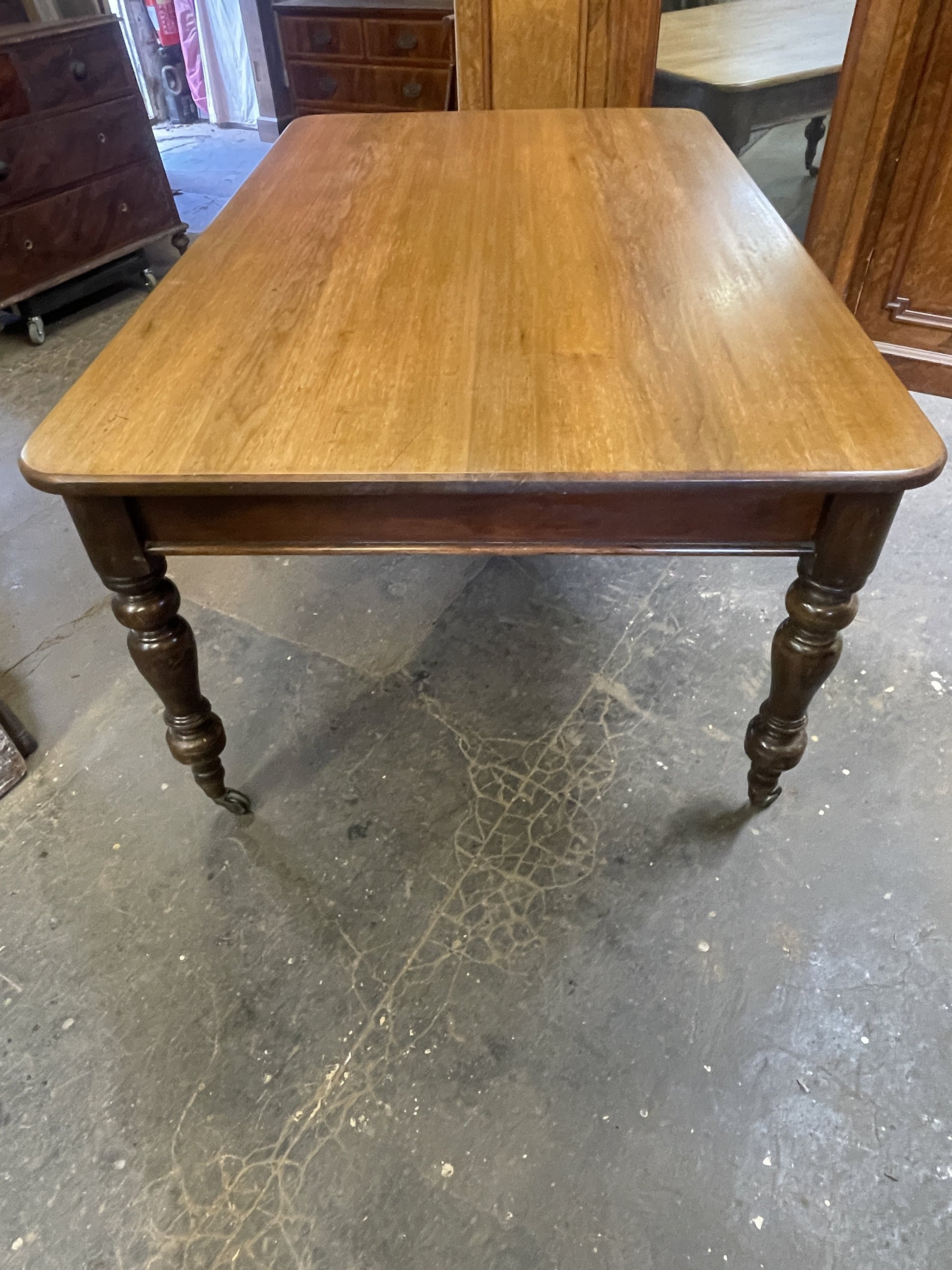 Wooden table with turned legs on a concrete floor