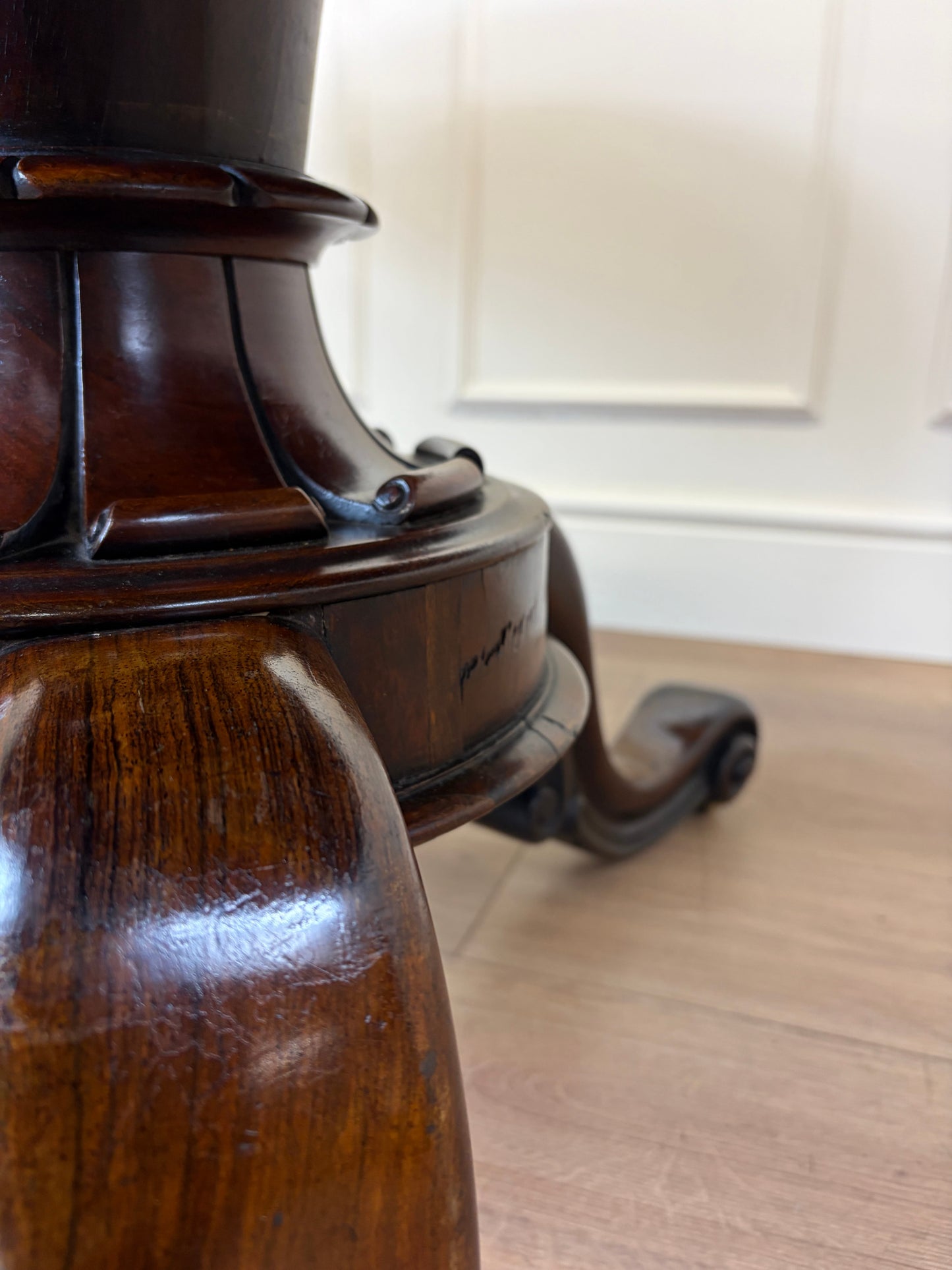 Close-up of a wooden pedestal on a wooden floor with a blurred background