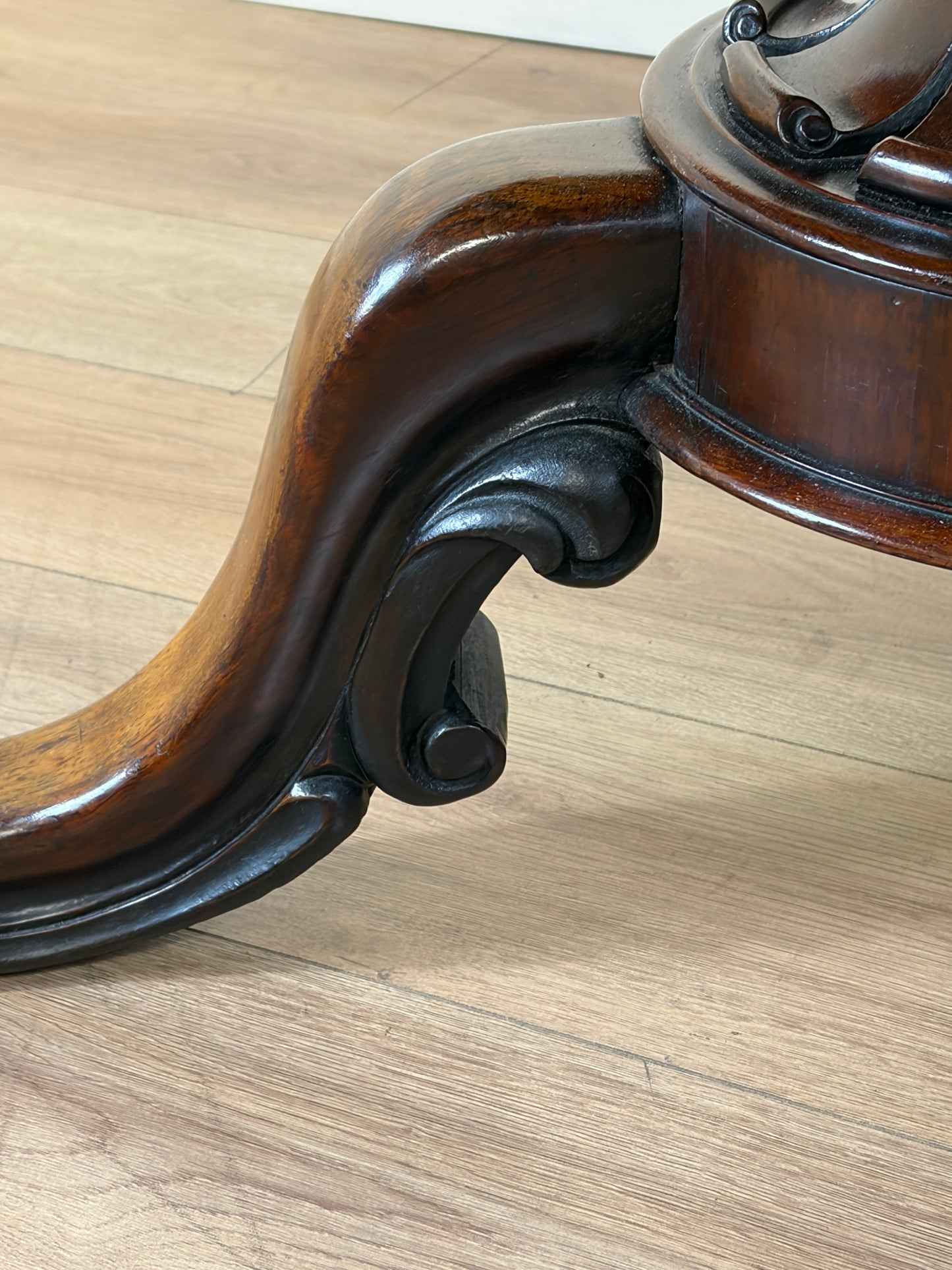 Close-up of a wooden chair leg on a wooden floor