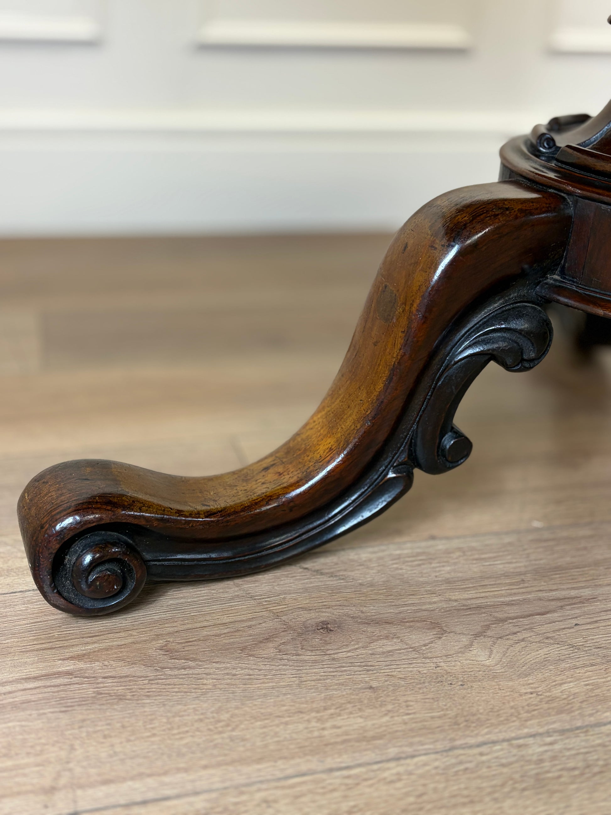 Wooden leg with intricate carvings on a wooden floor