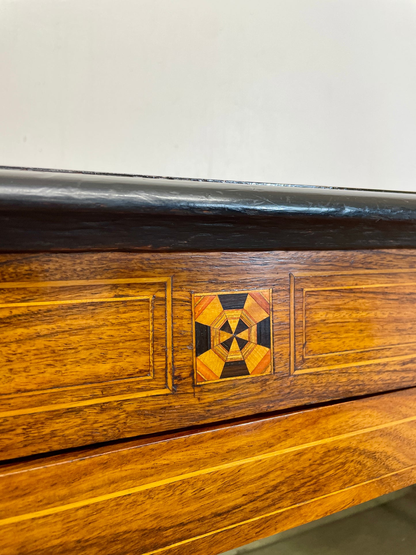 Close-up of a wooden surface with inlaid geometric pattern