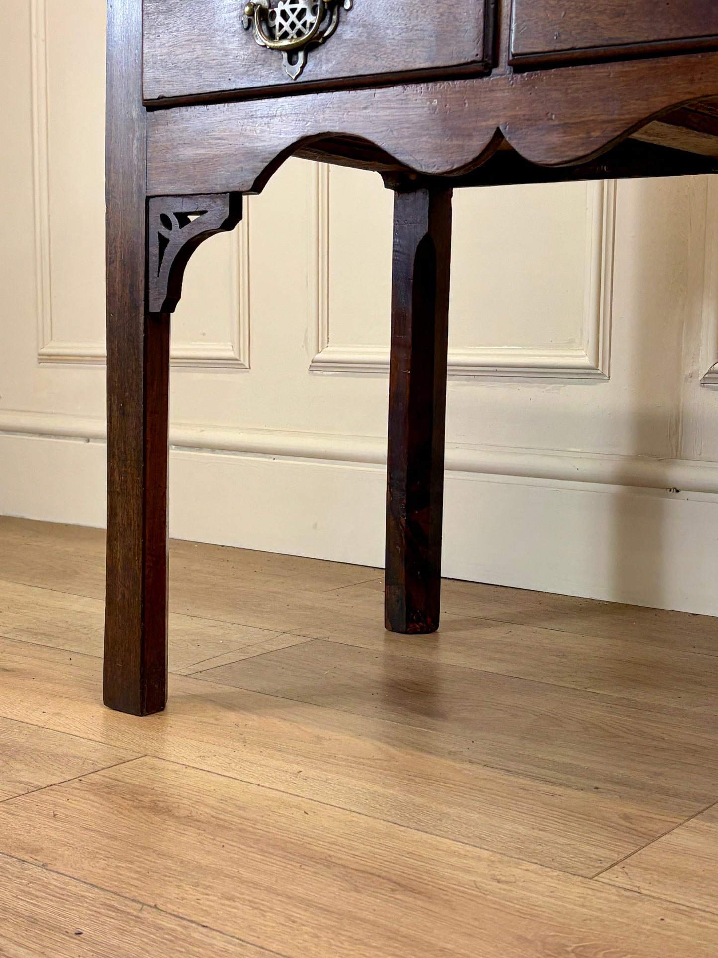 Wooden furniture leg on a wooden floor with a neutral wall background