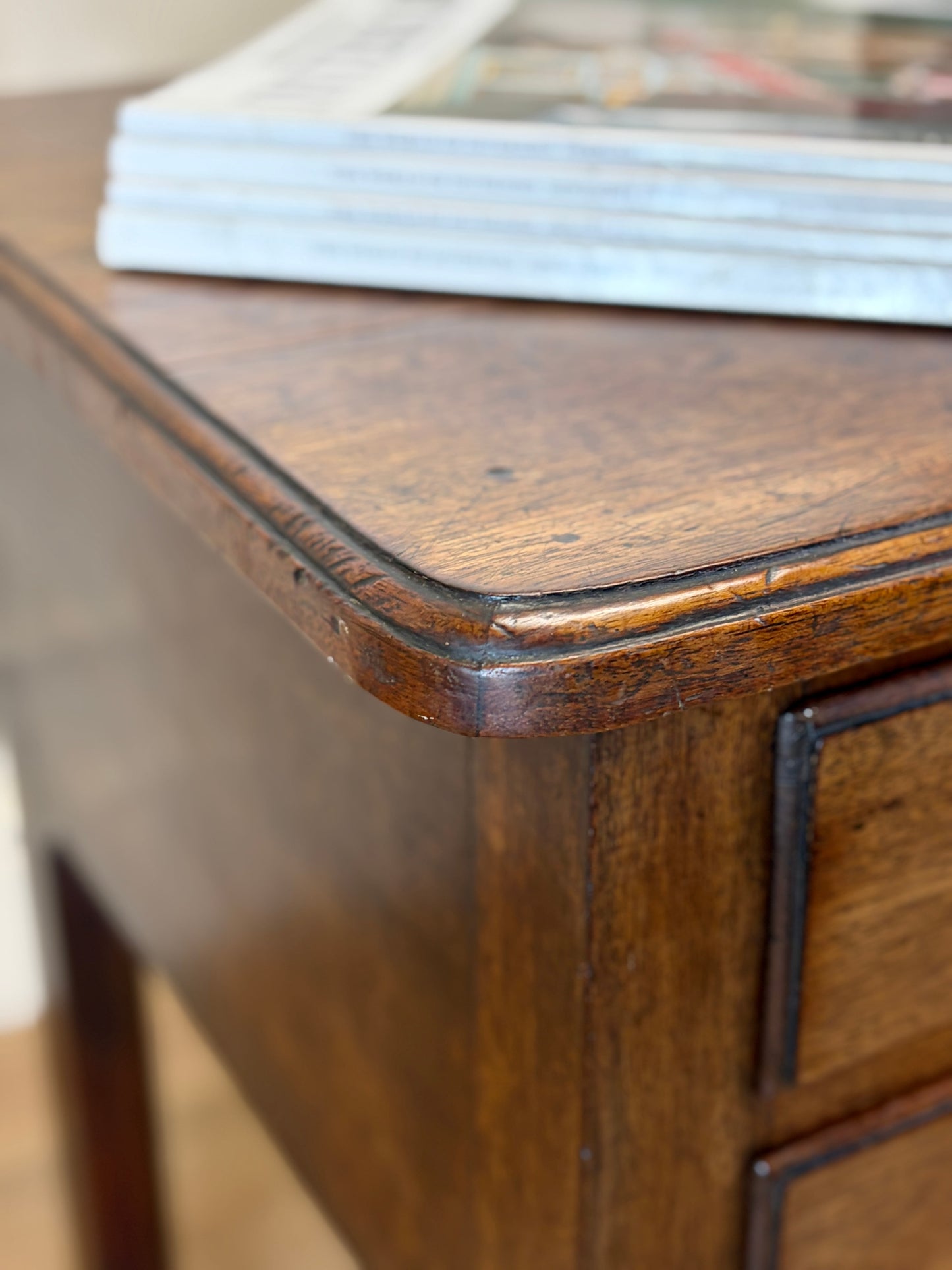 Close-up of a wooden desk corner with a glass top surface.