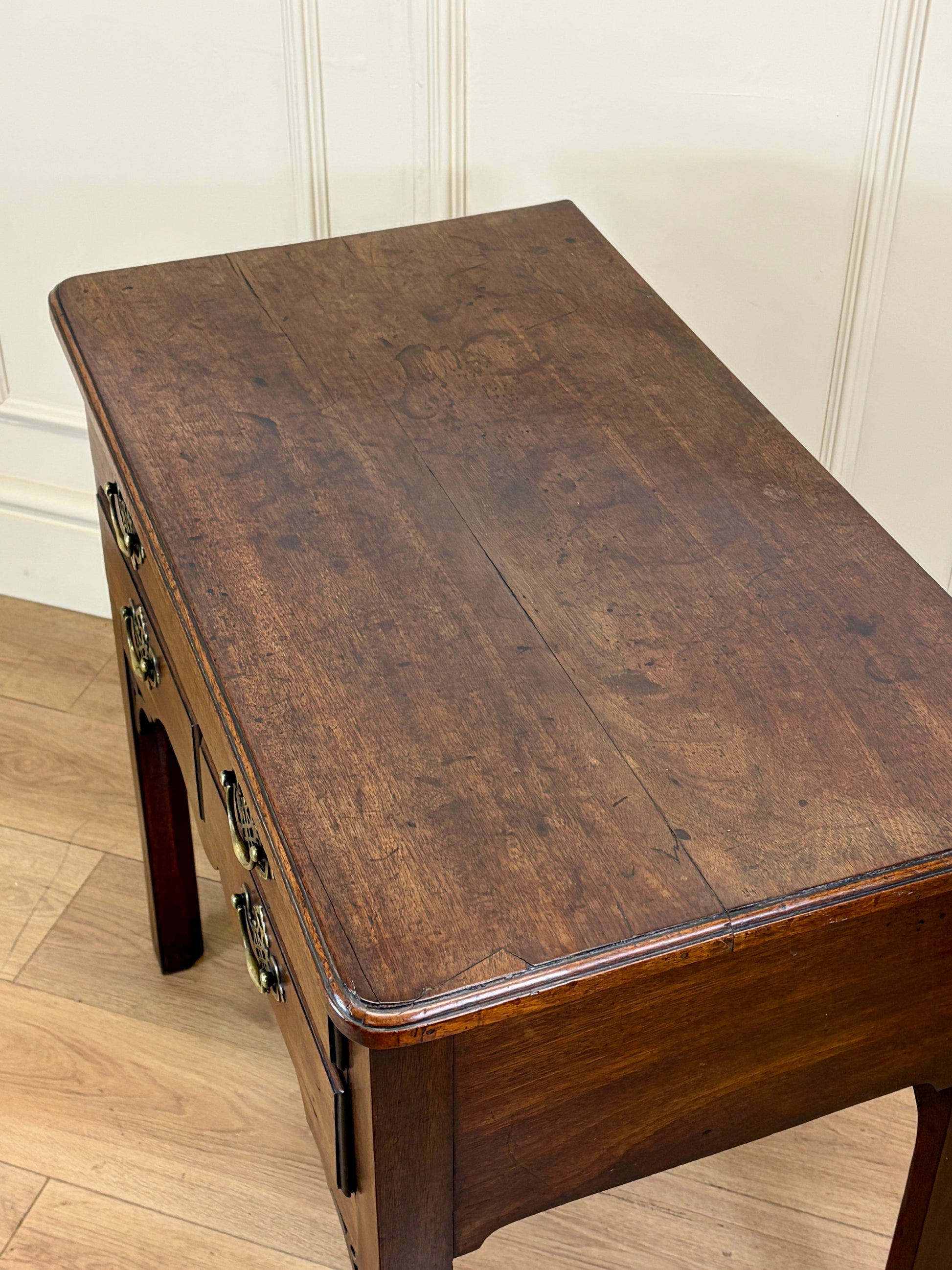 Wooden table with a worn surface on a wooden floor.