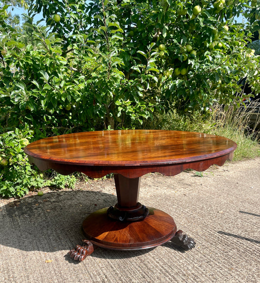 Wooden dining table outdoors with greenery in the background