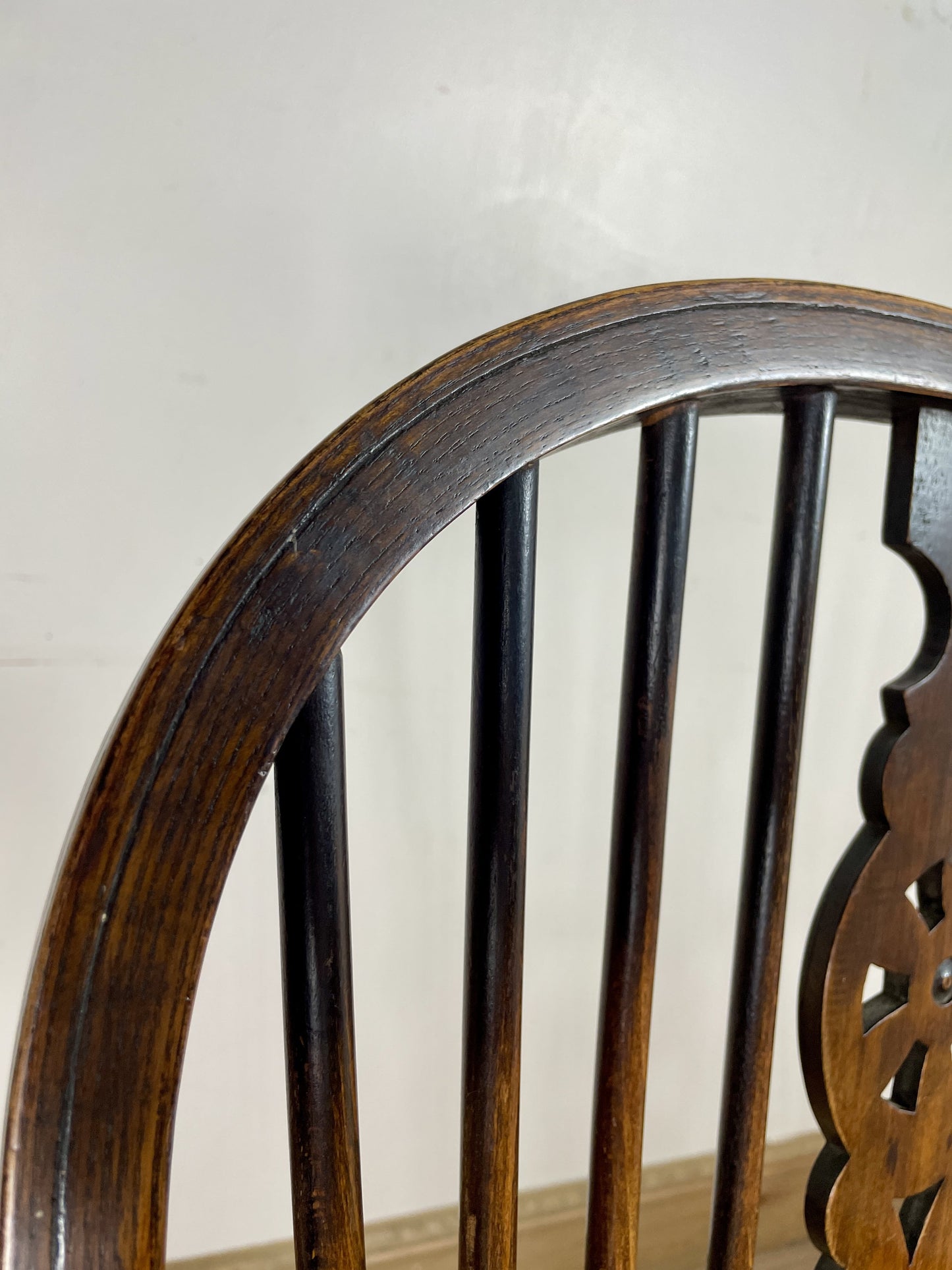 Close-up of a wooden chair with intricate design on a plain background