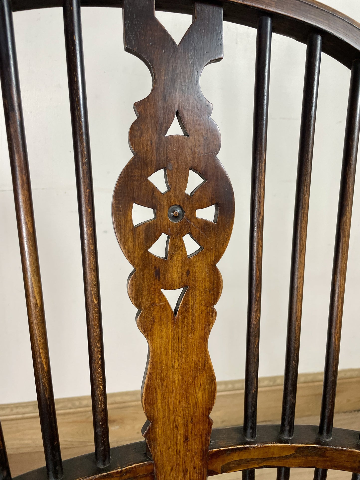 Close-up of a wooden chair back with intricate carvings on a plain background