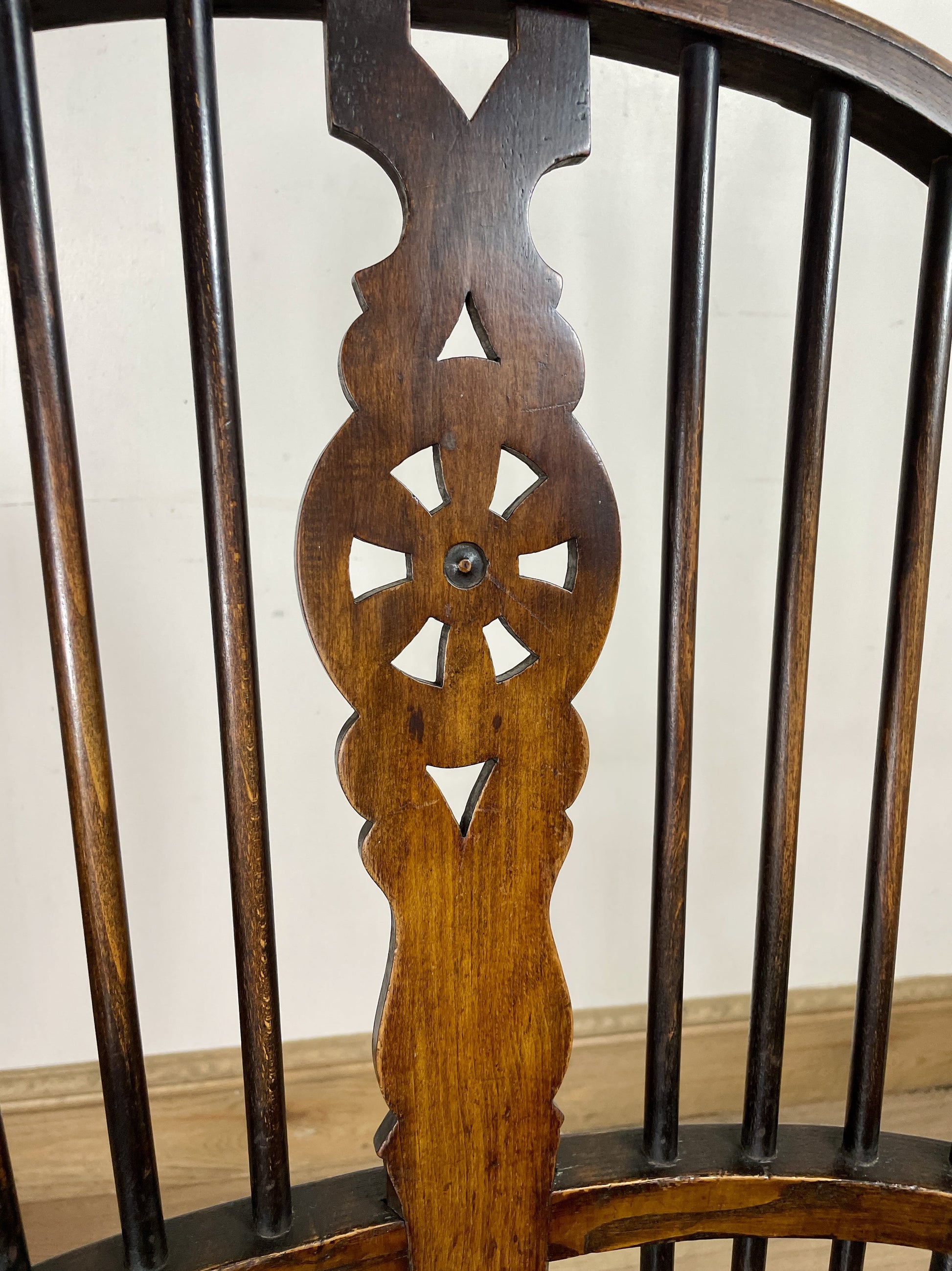 Close-up of a wooden chair back with intricate carvings on a plain background