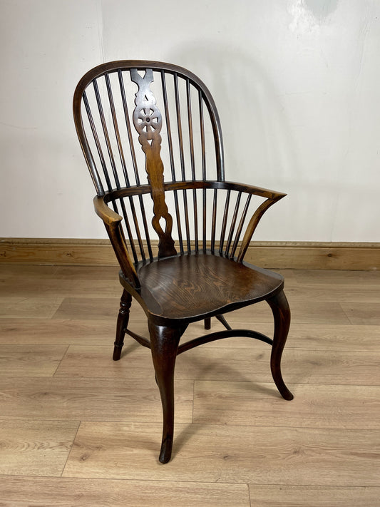 Wooden chair with a decorative backrest on a wooden floor.