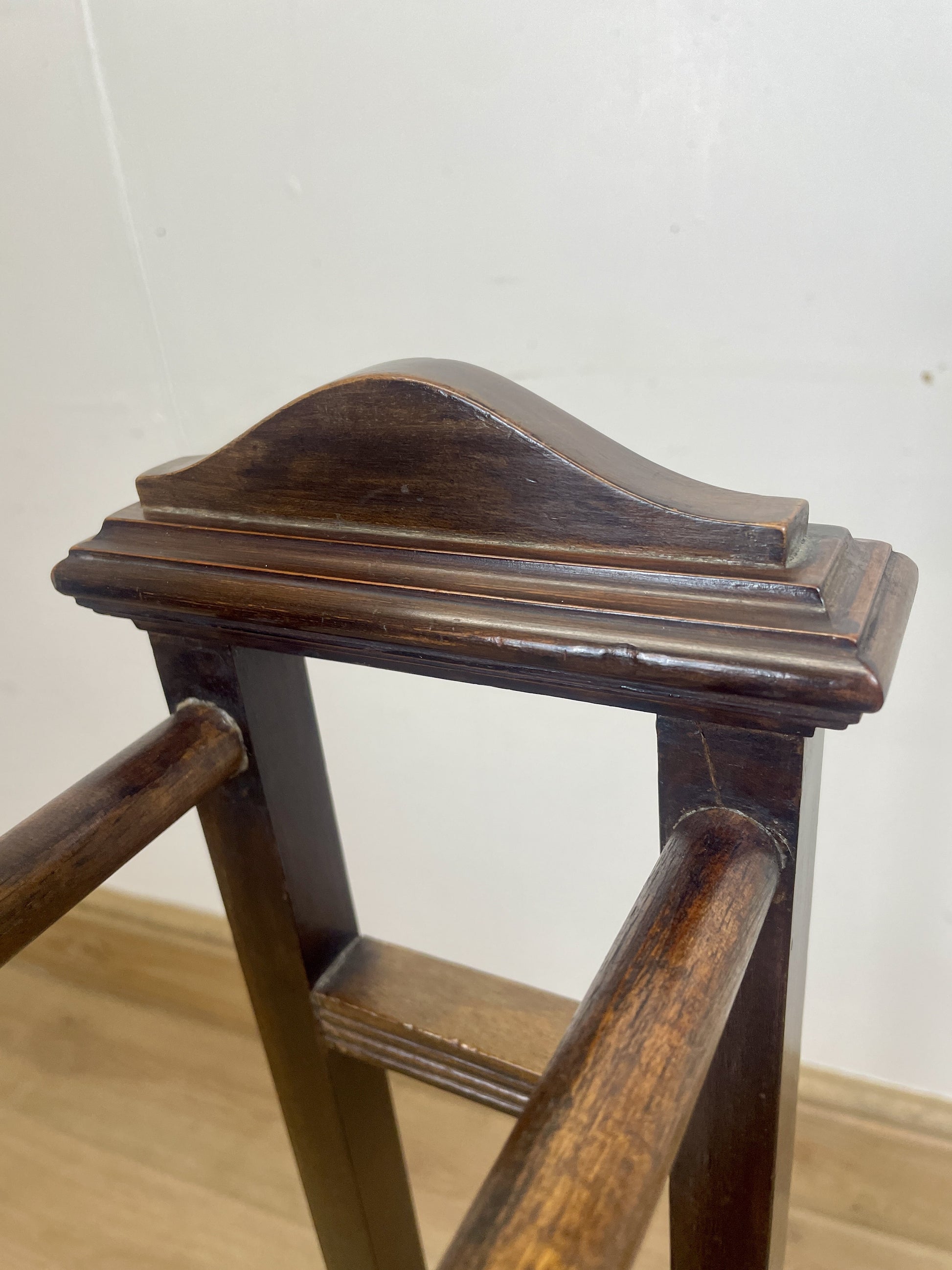 Wooden rail with a dark finish on a light wooden floor.