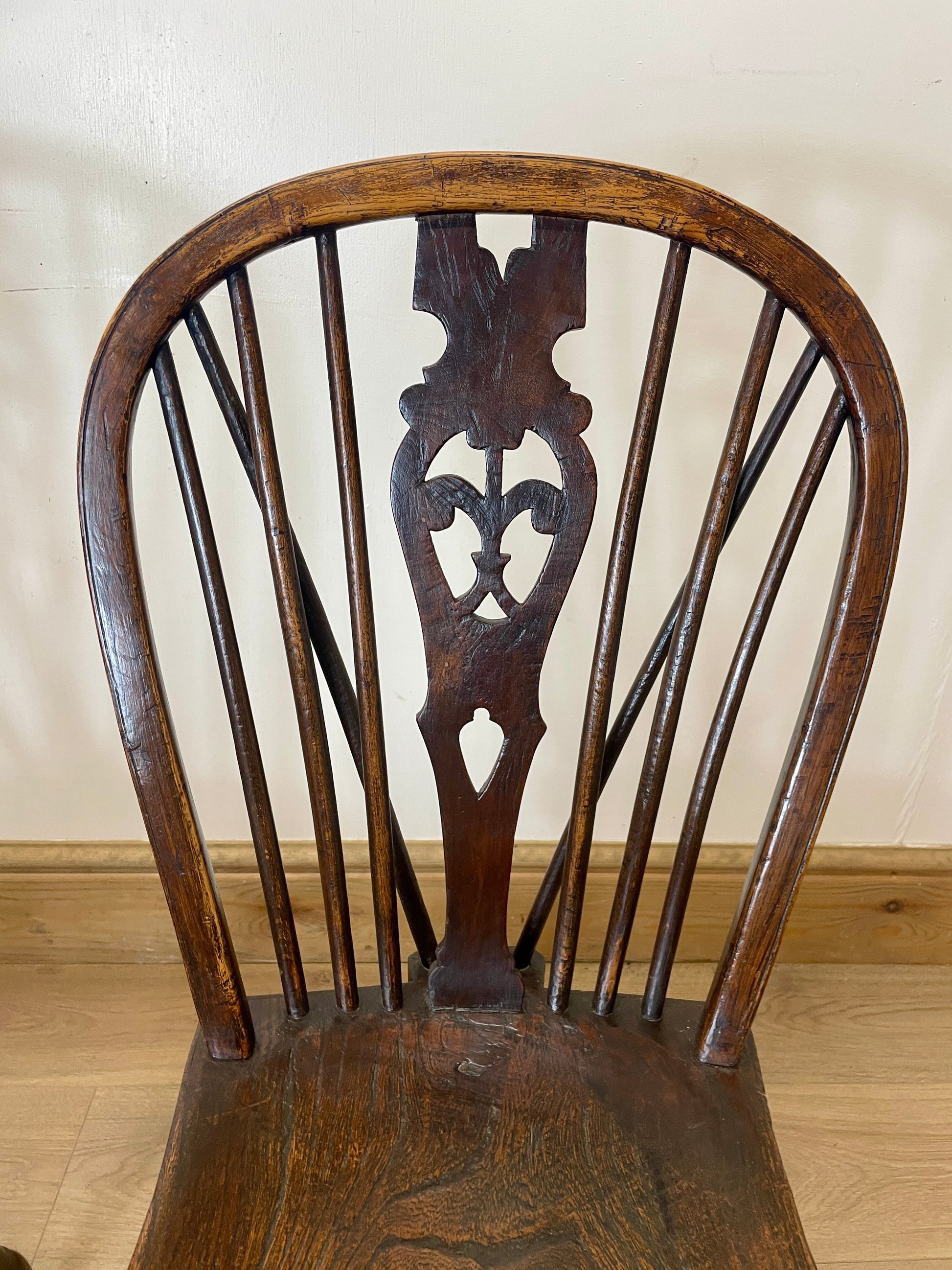 Wooden chair with intricate back design on a plain background